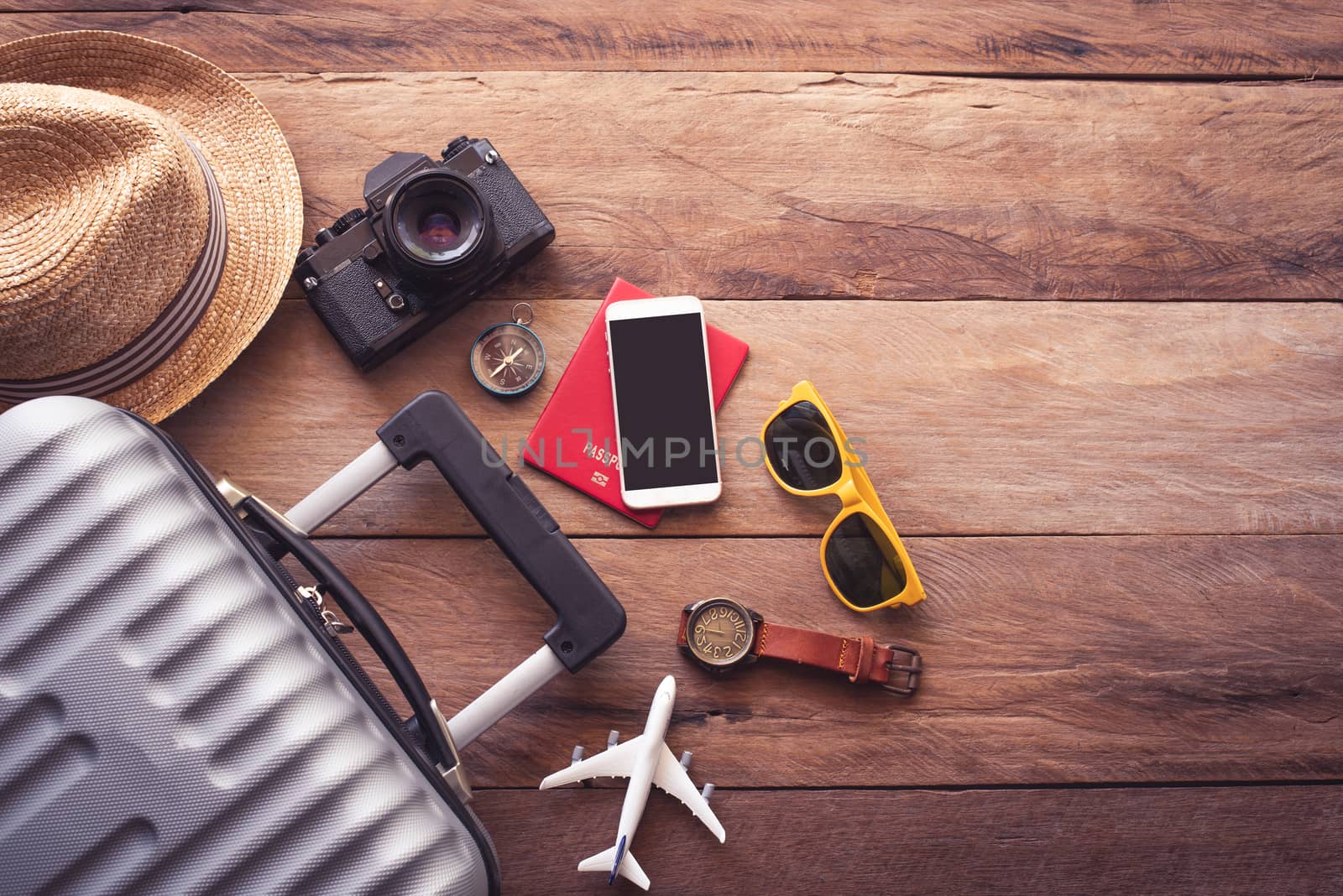 Clothing traveler's Passport, wallet, glasses, smart phone devices, on a wooden floor in the luggage ready to travel.