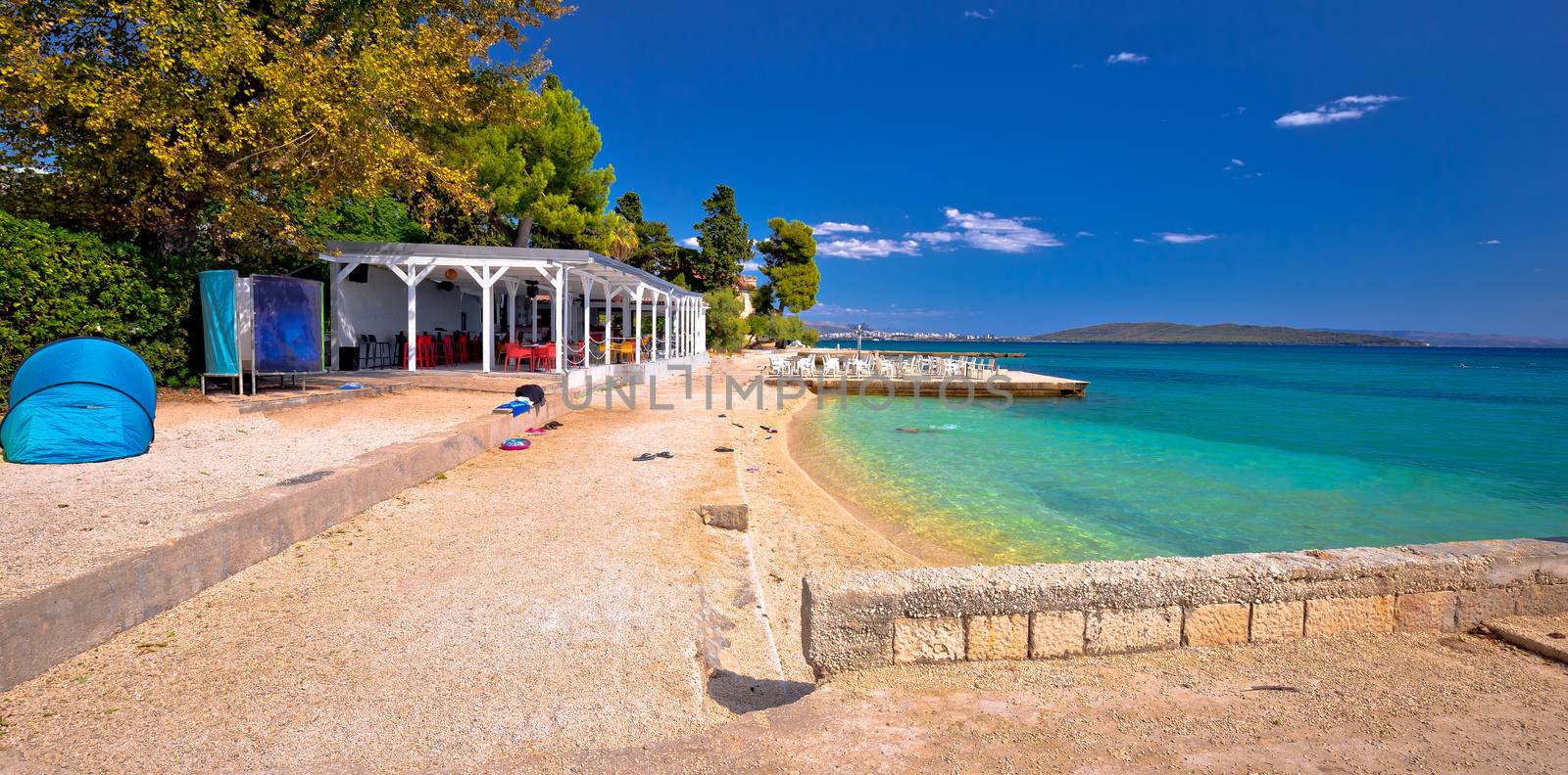 Idyllic turquoise beach and bar near Split panoramic view, Kastela bay in Croatia