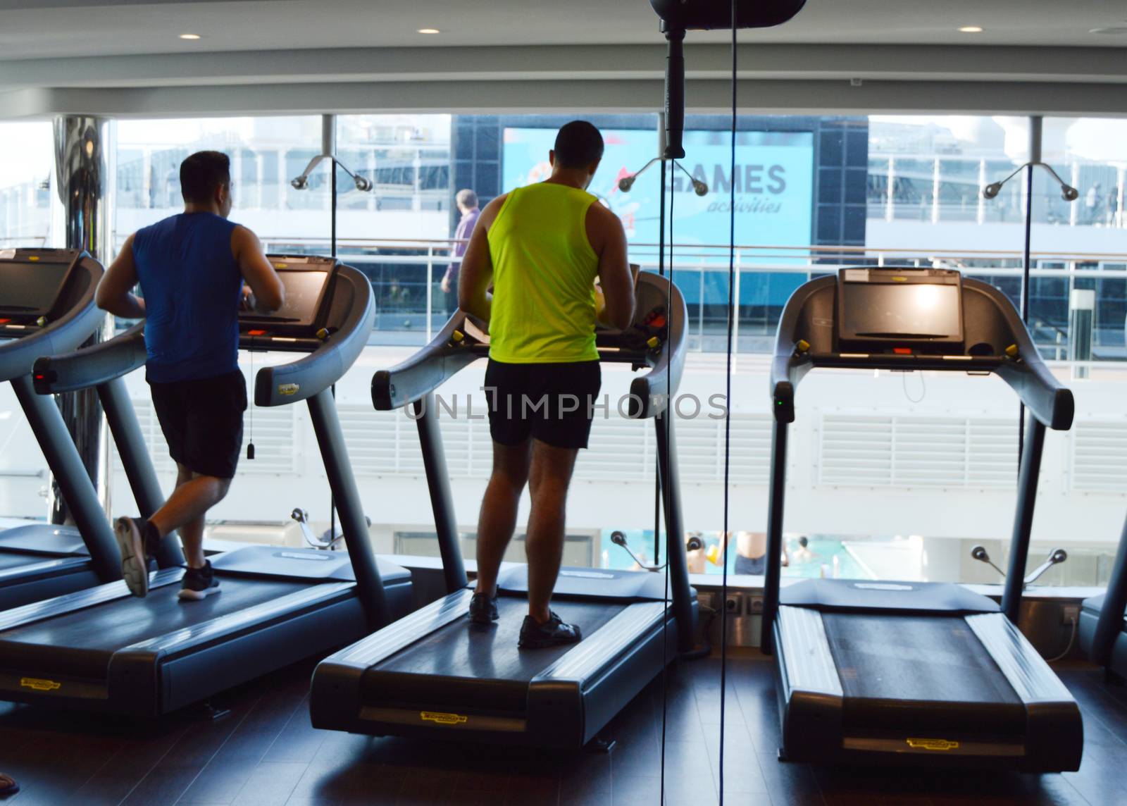 Modern gym with treadmills, people do sports on a cruise ship, the view from the back. MSC Meraviglia, 8 October 2018 by claire_lucia