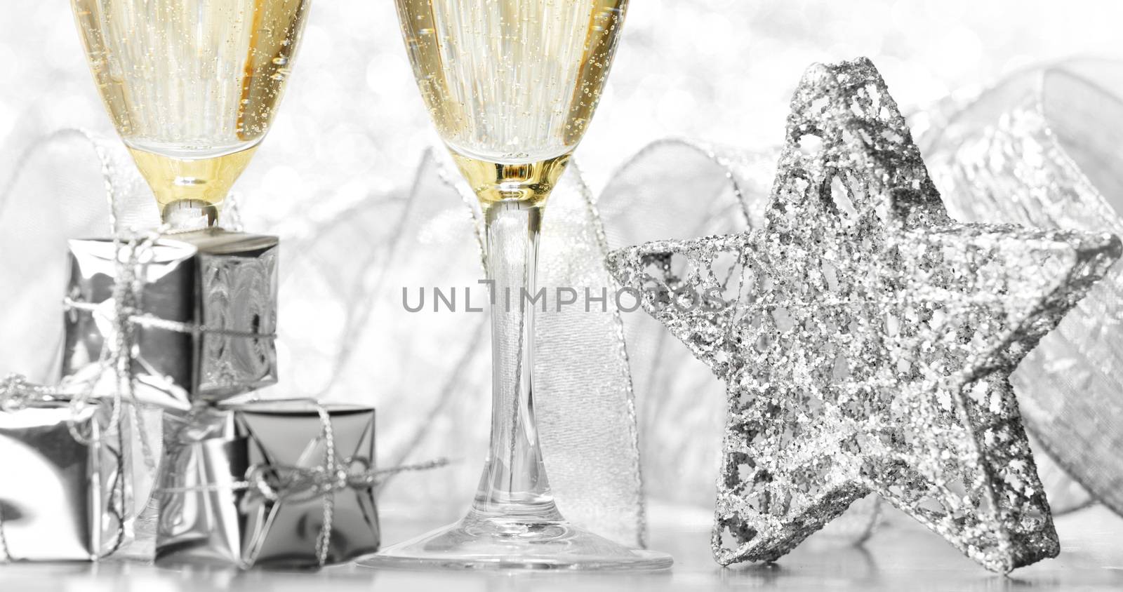 Glasses of champagne and christmas decoration on silver background