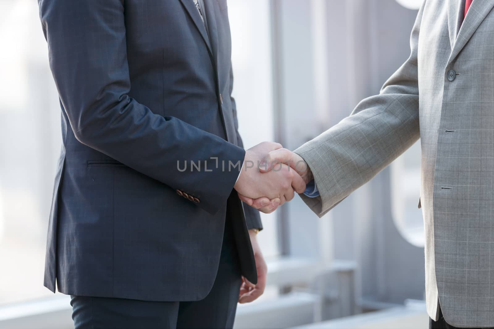 Business people in formal wear shaking hands close up view