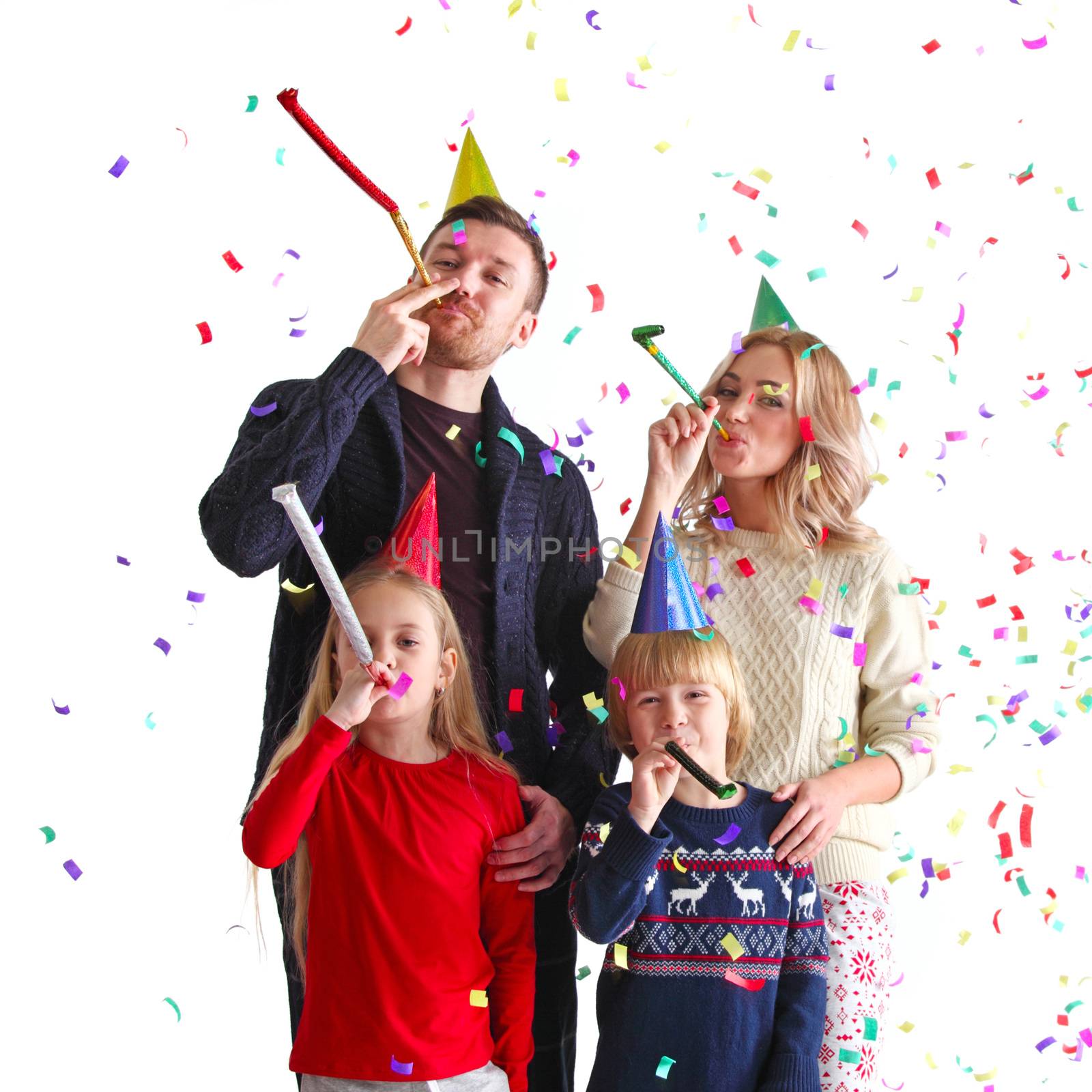 Family blowing party trumpets with confetti by ALotOfPeople