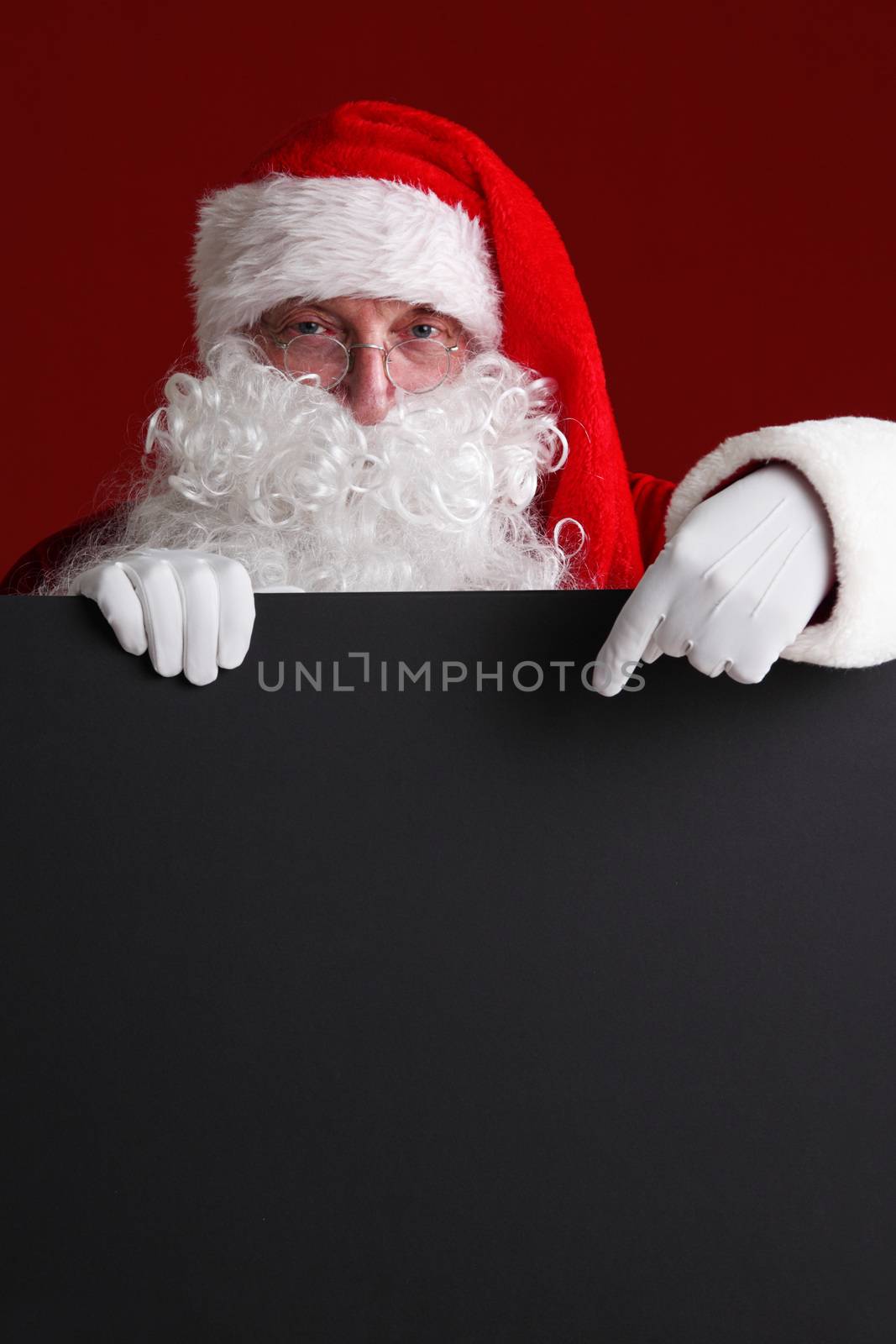 Santa Claus holding black paper billboard with copy space for text