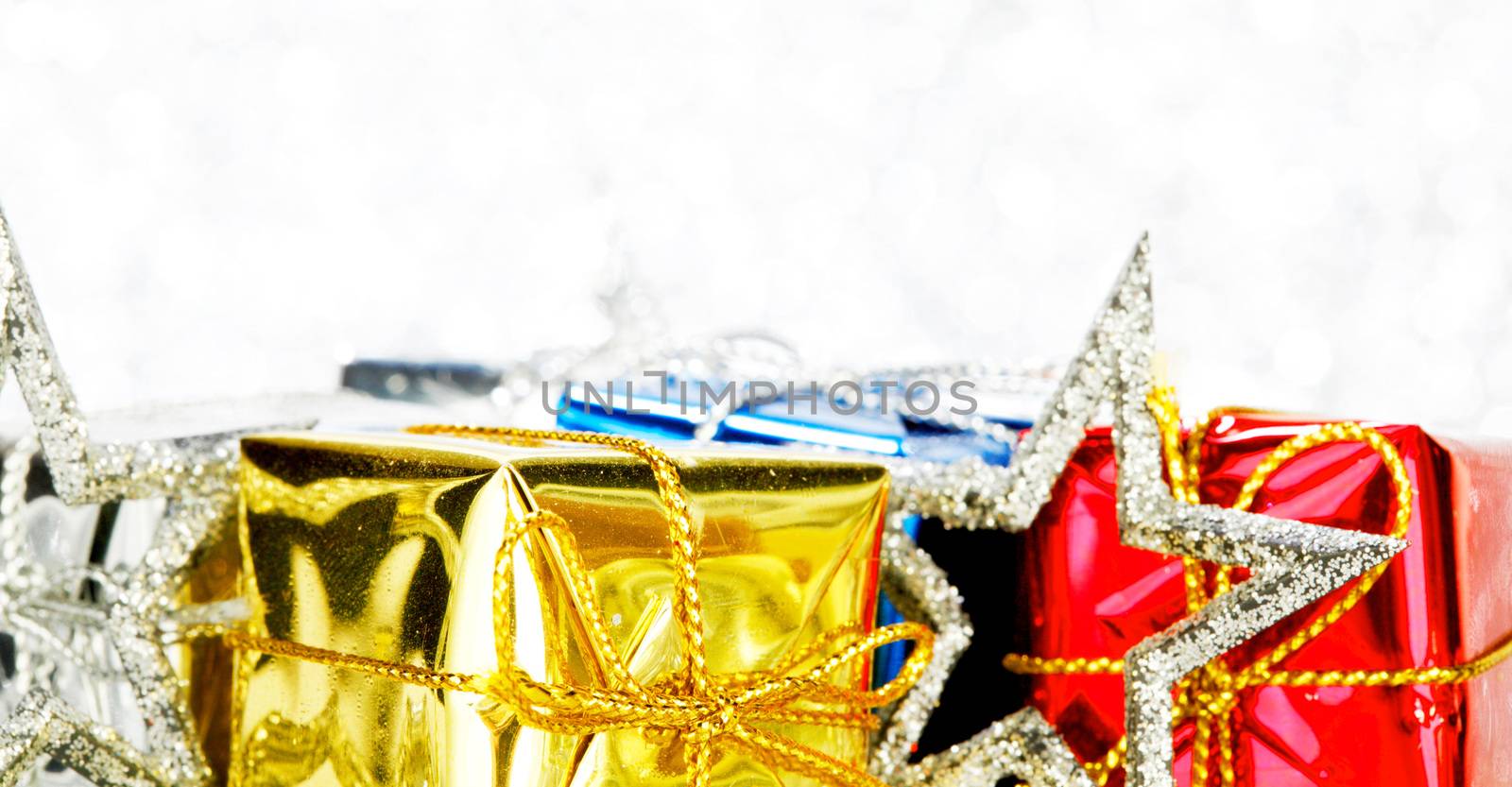 Decorated holiday gifts on silver background