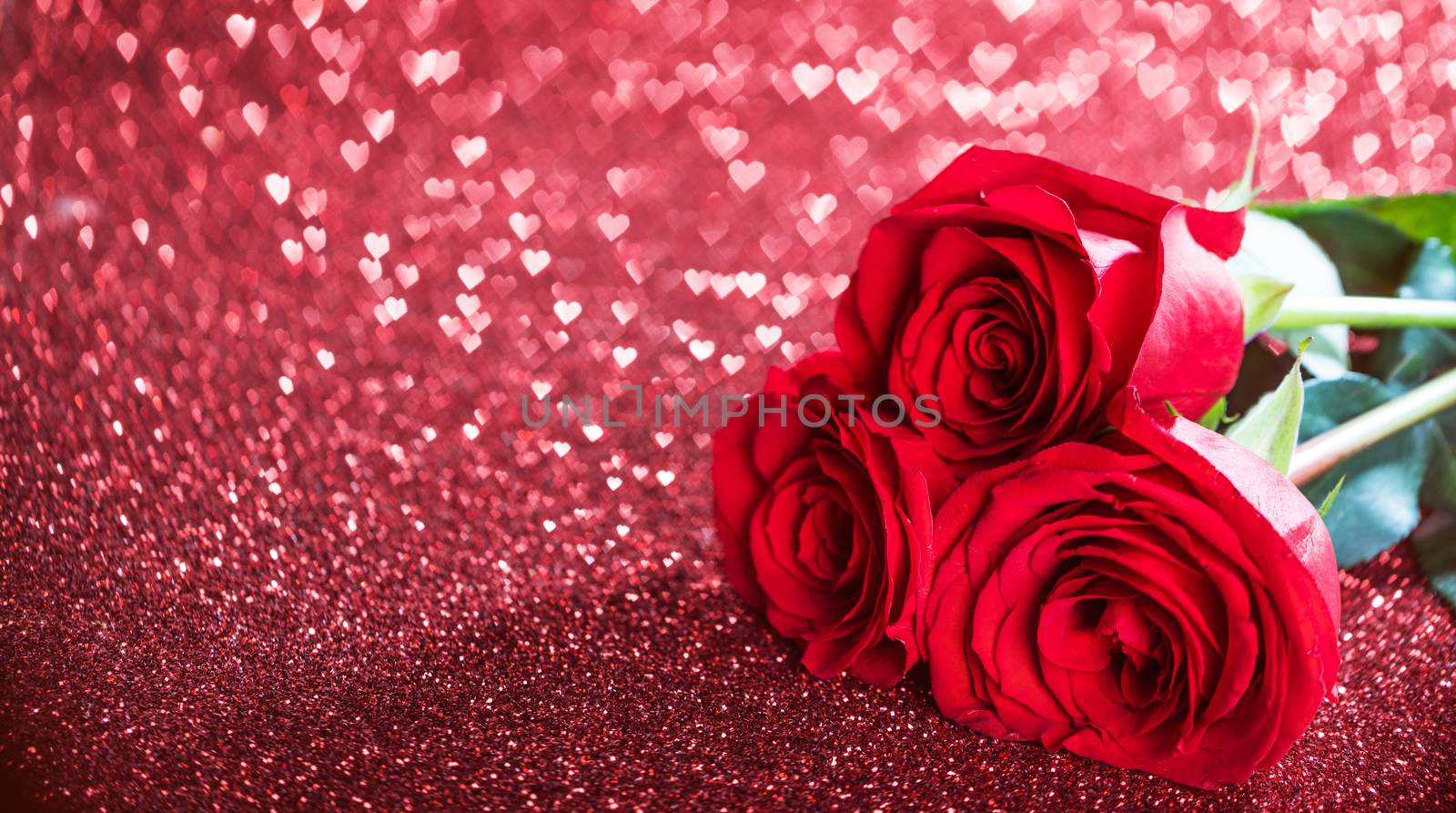 Three beautiful red roses on heart shape bokeh glitter background