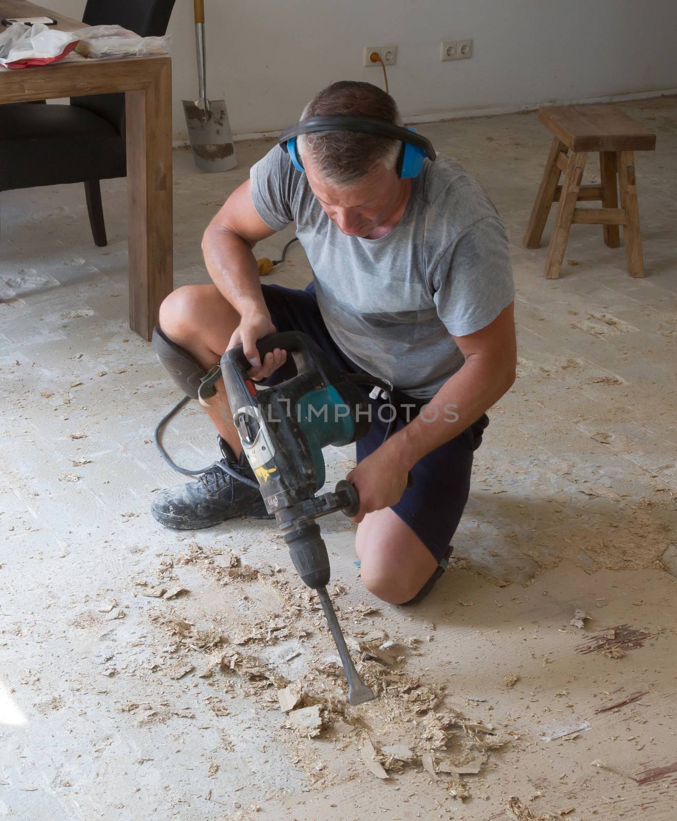 Construction concept - Jackhammer, removing chipboard from the floor - Selective focus