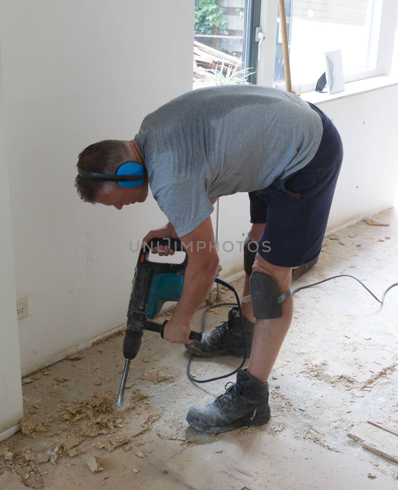 Construction concept - Jackhammer, removing chipboard from the floor - Selective focus