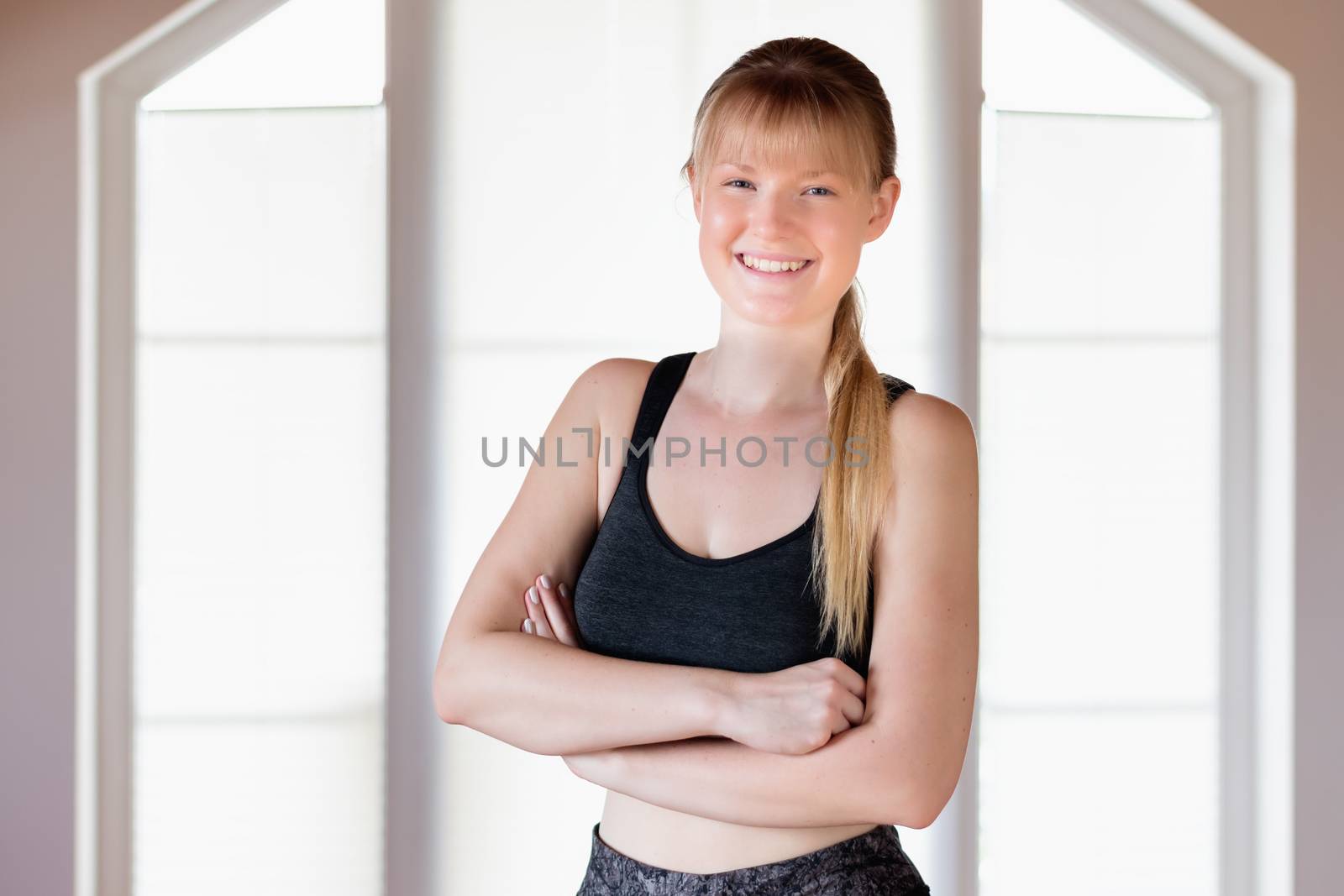 Happy young girl doing squat exercises at home
