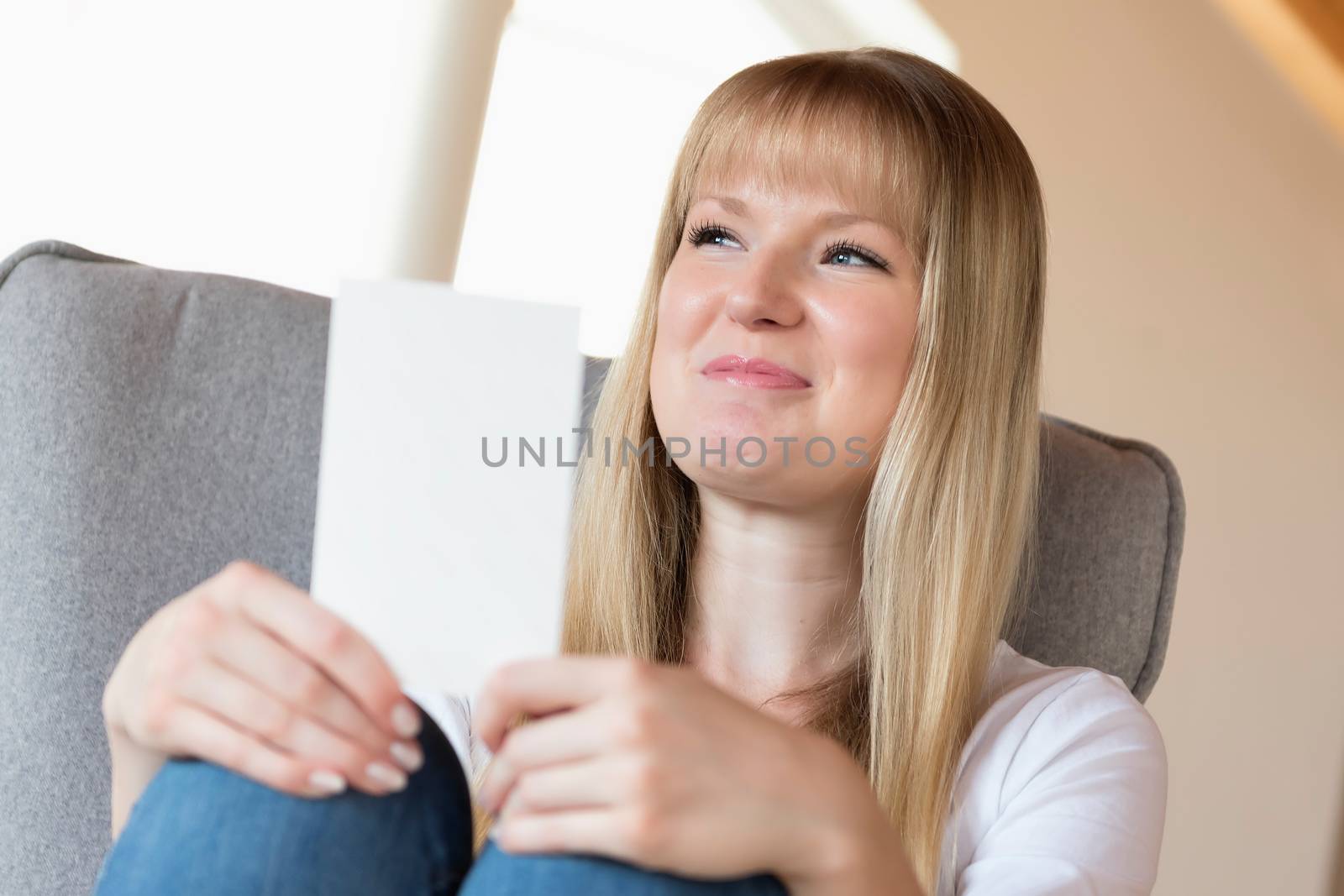 Happy young sitting woman holding a photo