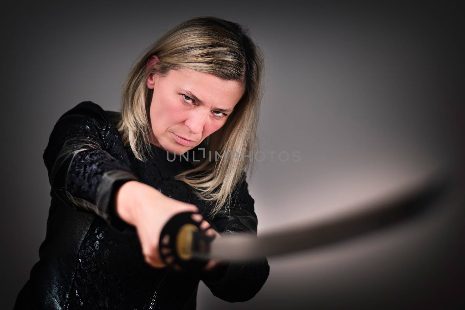 Strong female fighter with samurai sword in action