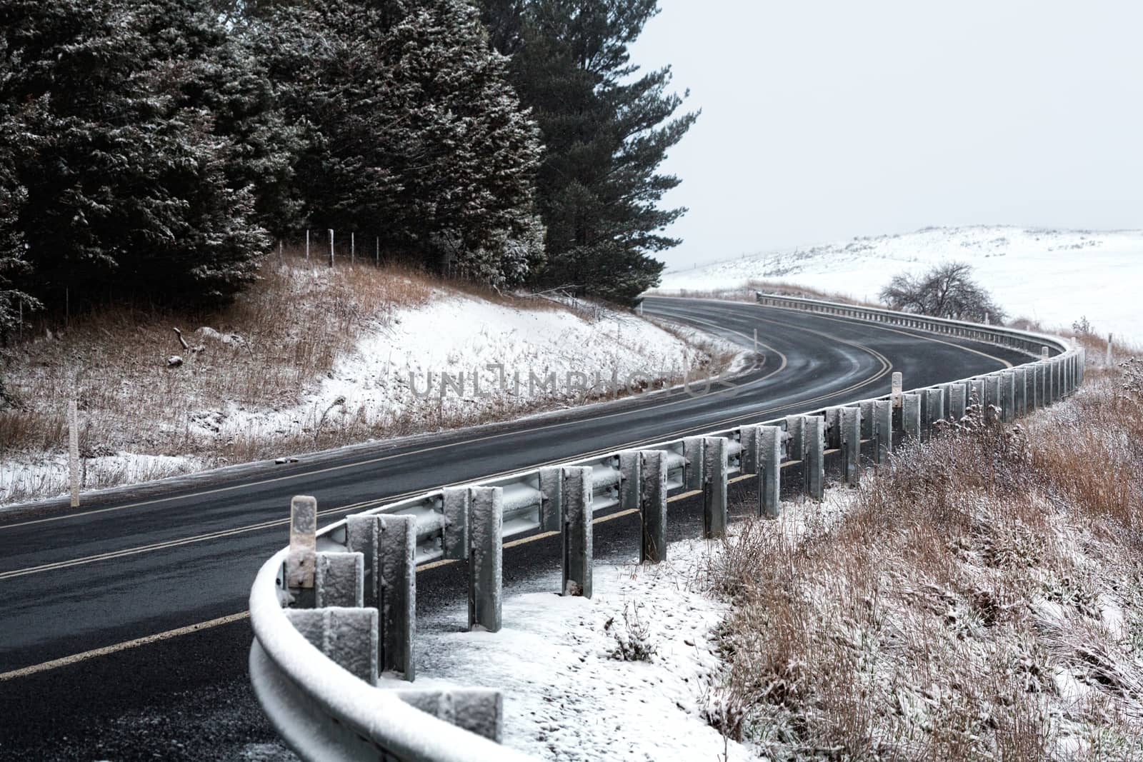 Curving highway through snow covered hills in winter