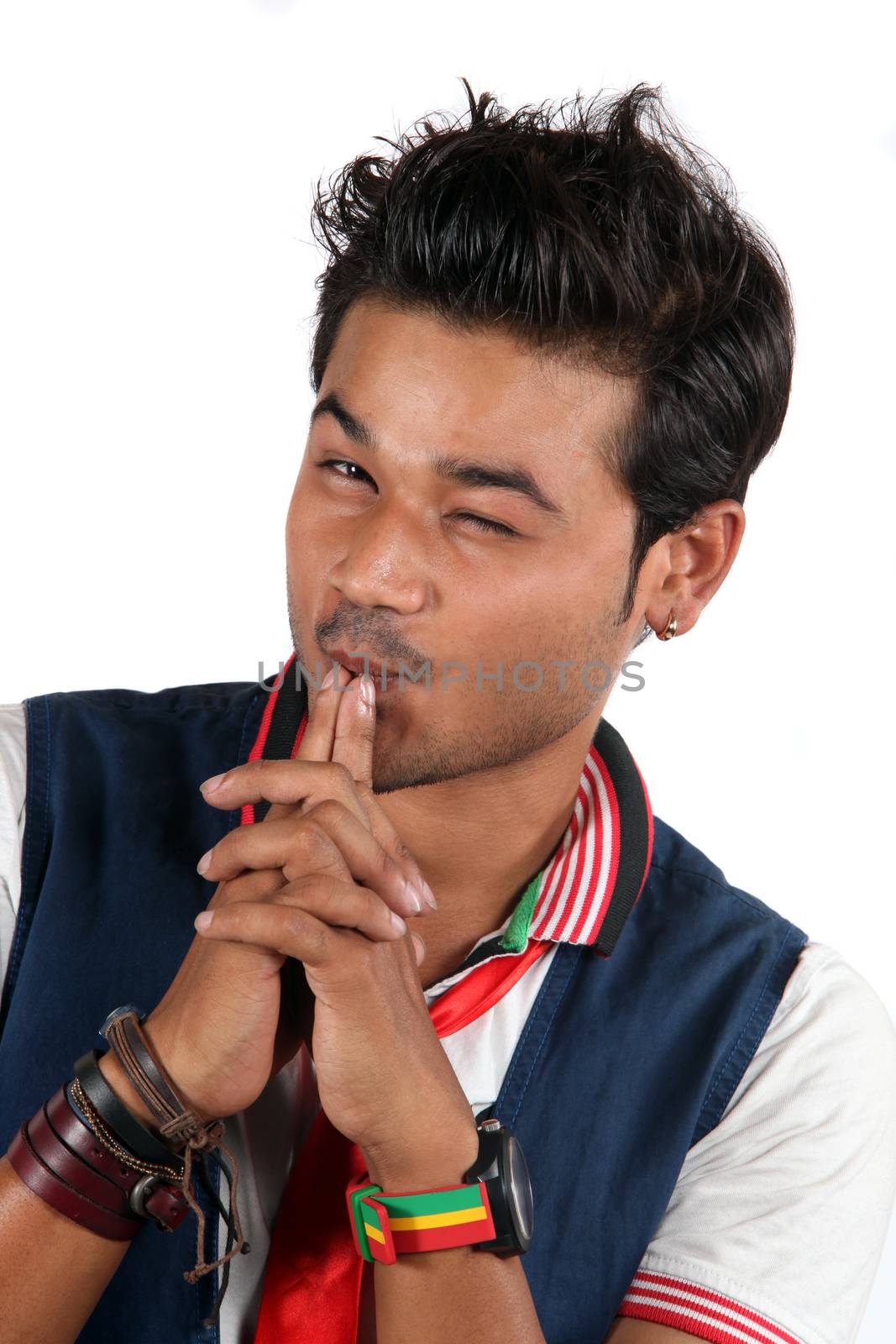 A young stylish Indian guy winking, on a white studio background