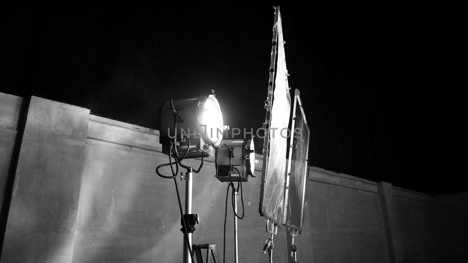 Black and white images of big studio continue LED light for video or film movie production on professional strong steel tripod and promt for shooting or set framing for director