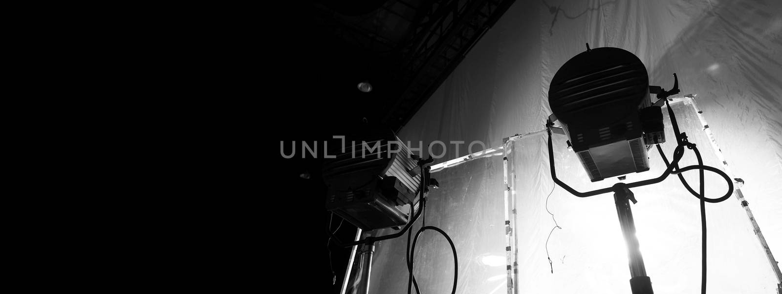 Black and white images of big studio continue LED light for video or film movie production on professional strong steel tripod and promt for shooting or set framing for director