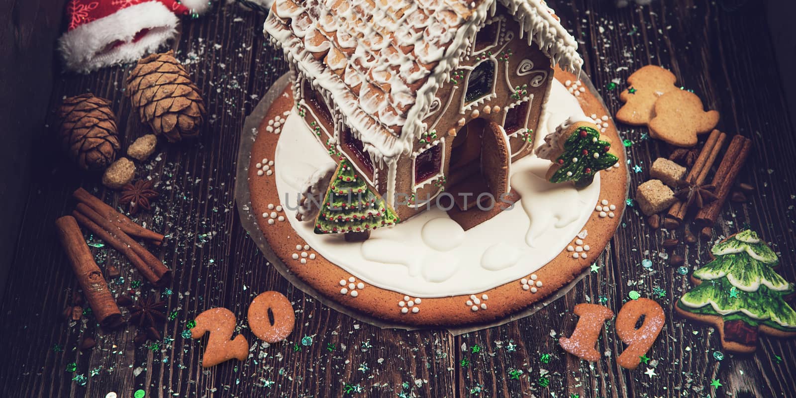 Gingerbread house and figures with lights on dark background, xmas theme