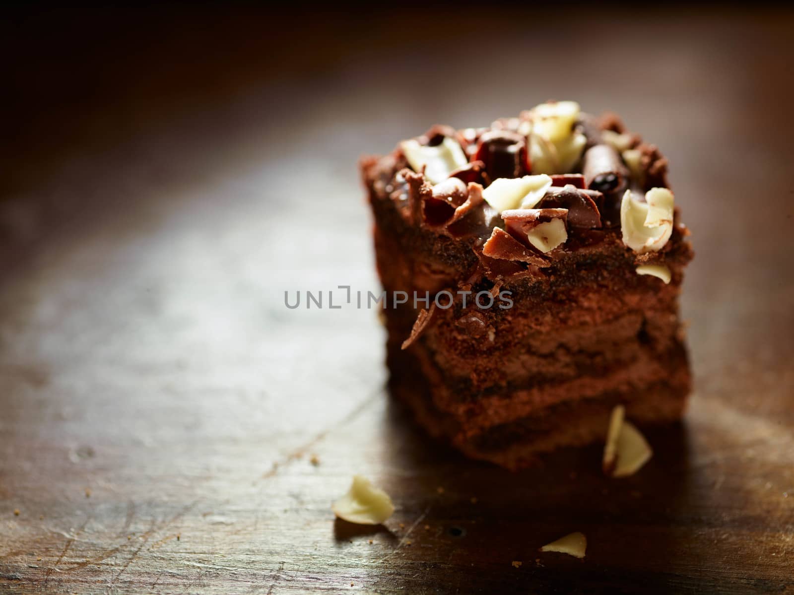 A closeup of a delicious piece of chocolate cake on a wooden table.