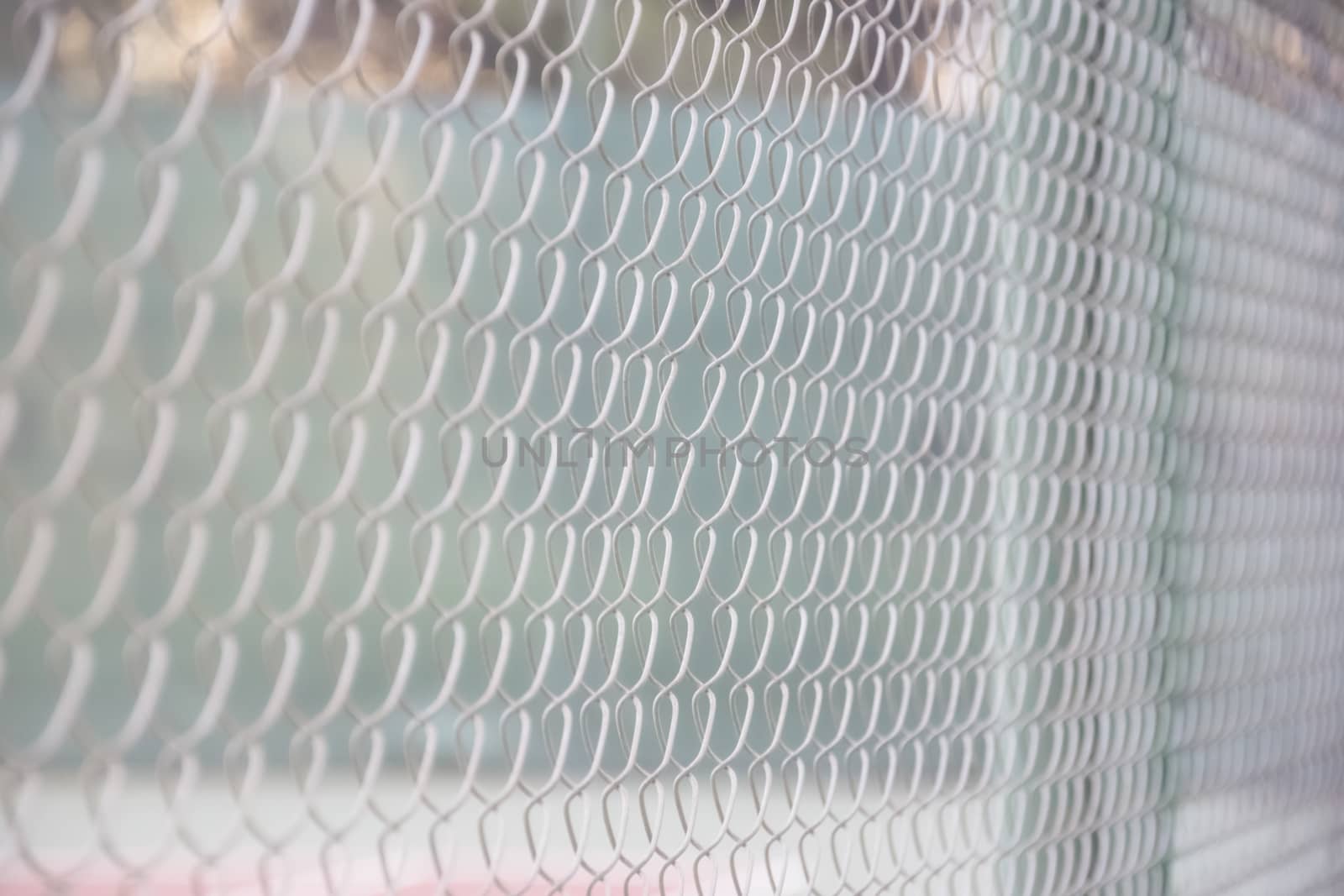 Grid a chain-link a fence on the tennis court a light background