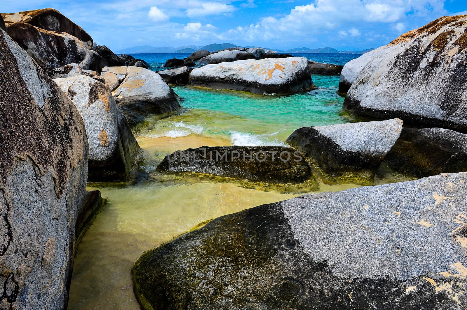 An amazing colours from yellow to turquoise of the beaches of Virgin Gorda in contrast with the blue sky and the rocks