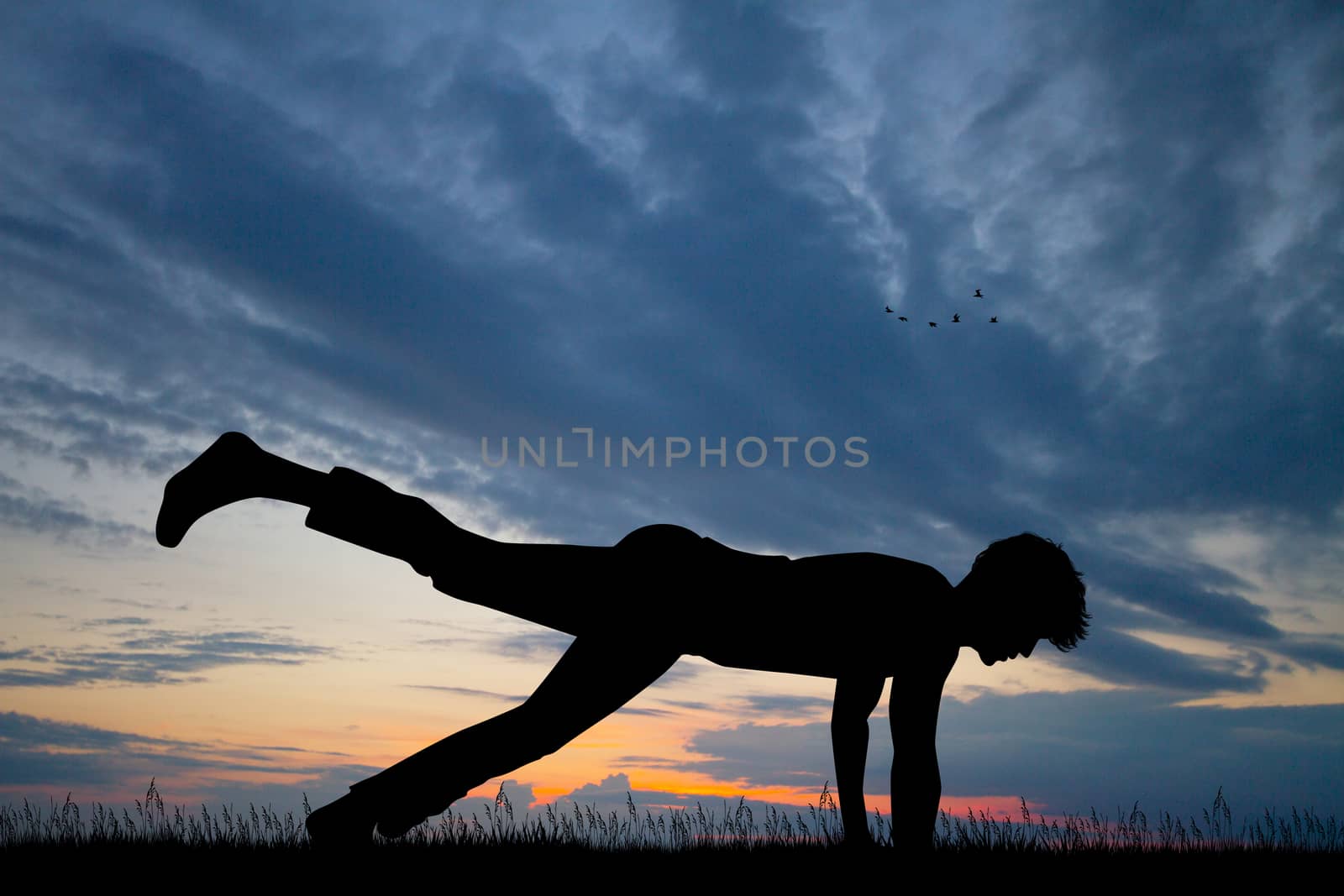 man makes push-ups on his arms at sunset by adrenalina