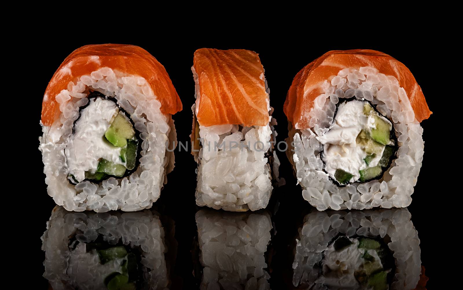 Three pieces of sushi rolls Philadelphia. Black background. Reflection.