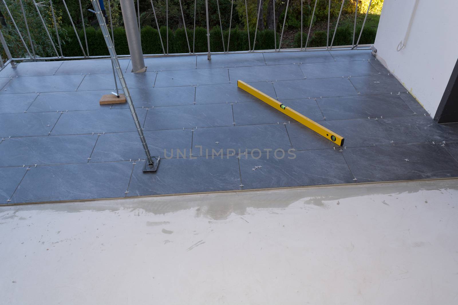 Balcony floor tiles installation. Laying tiles from porcelain. Interior remodeling theme.