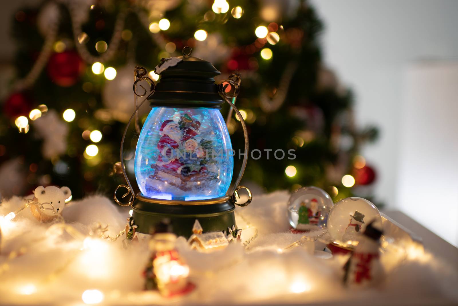 Christmas decoration, snow dome, globe with table decoration, Santaclaus on sleigh with child in winter scene with snowflakes, reindeer snowglobe and polar bears, tree in background