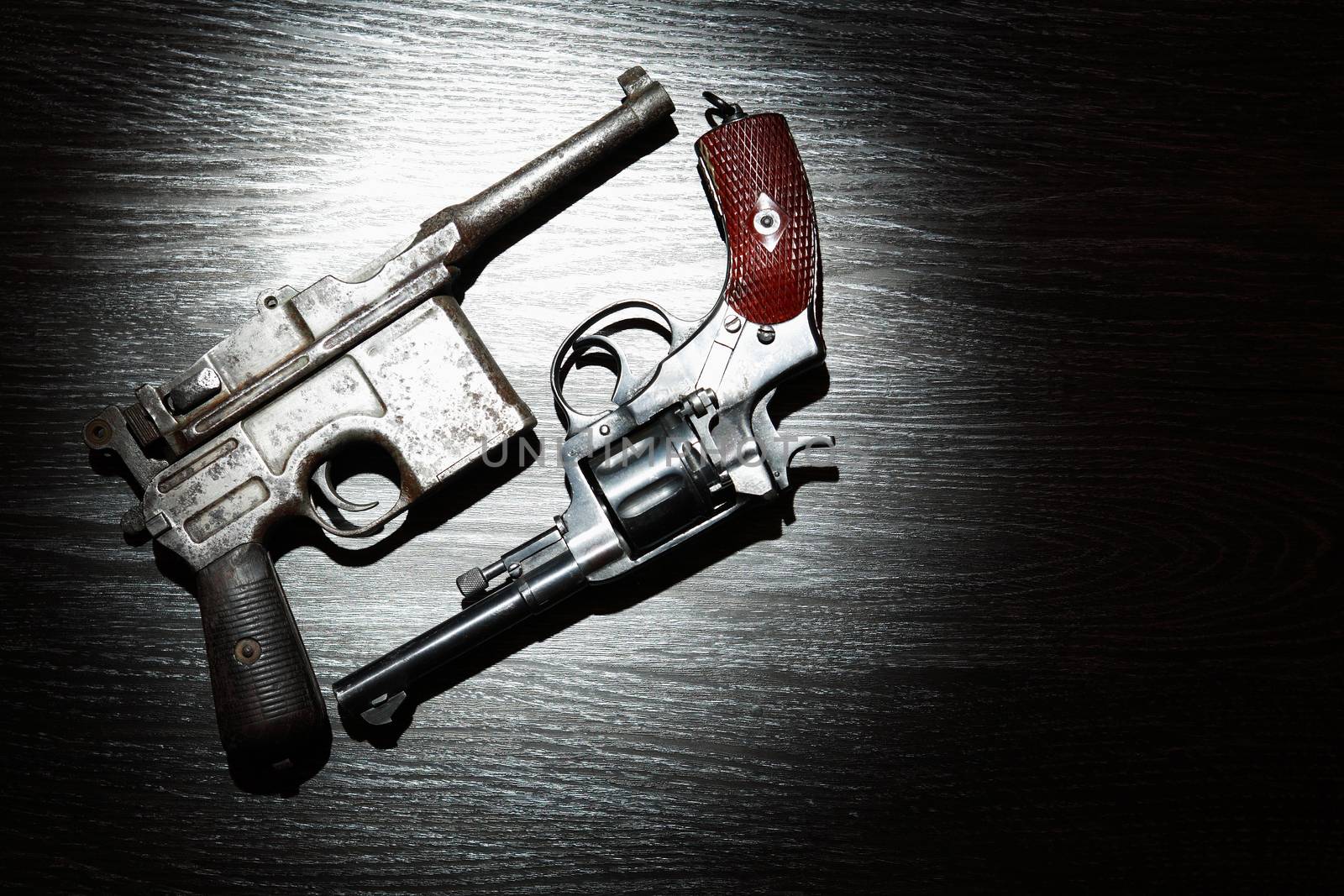 Old revolver and pistol closeup on dark background