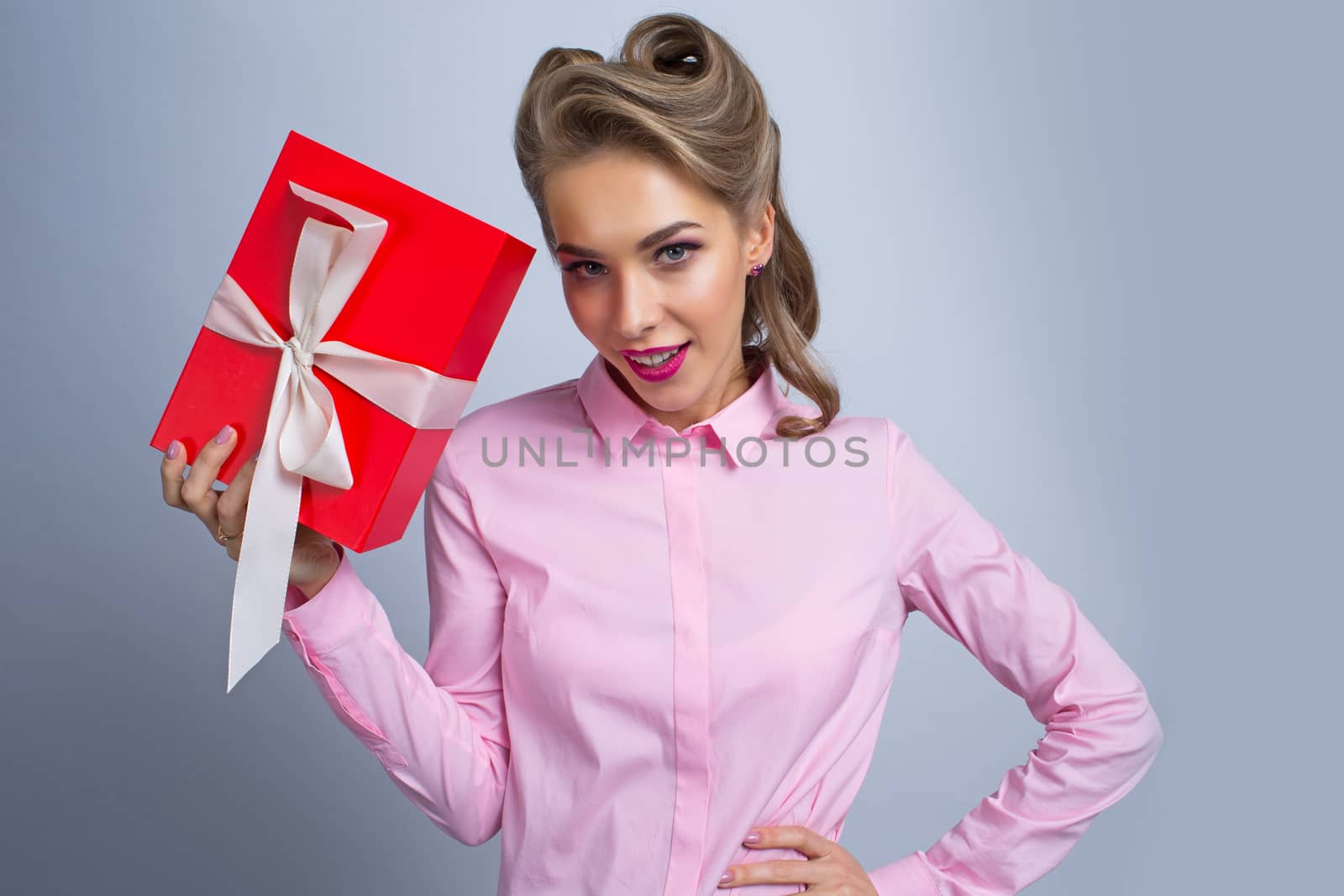 Happy beautiful funny woman holding red gift box with white ribbon