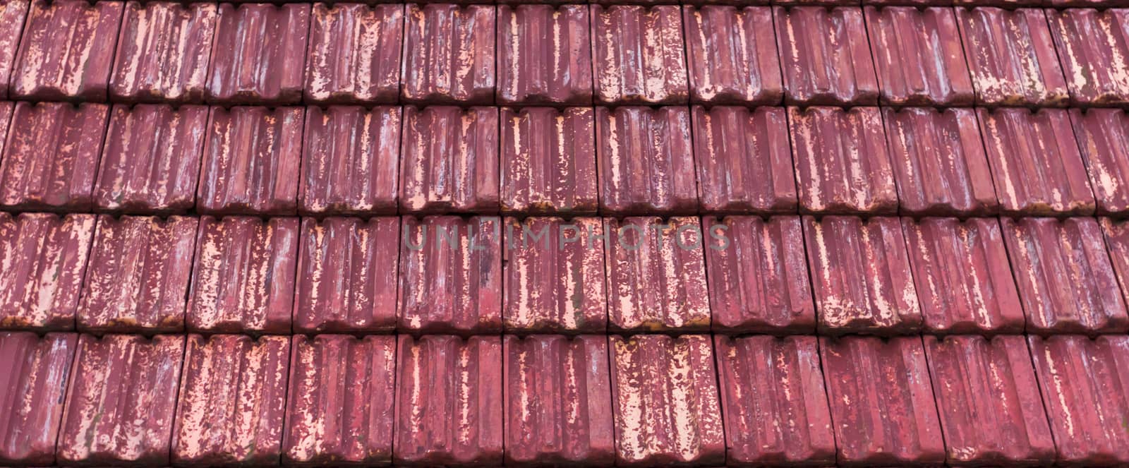 weathered and old red colored classic stone roof tiling with faded out colors, architecture texture pattern background by charlottebleijenberg