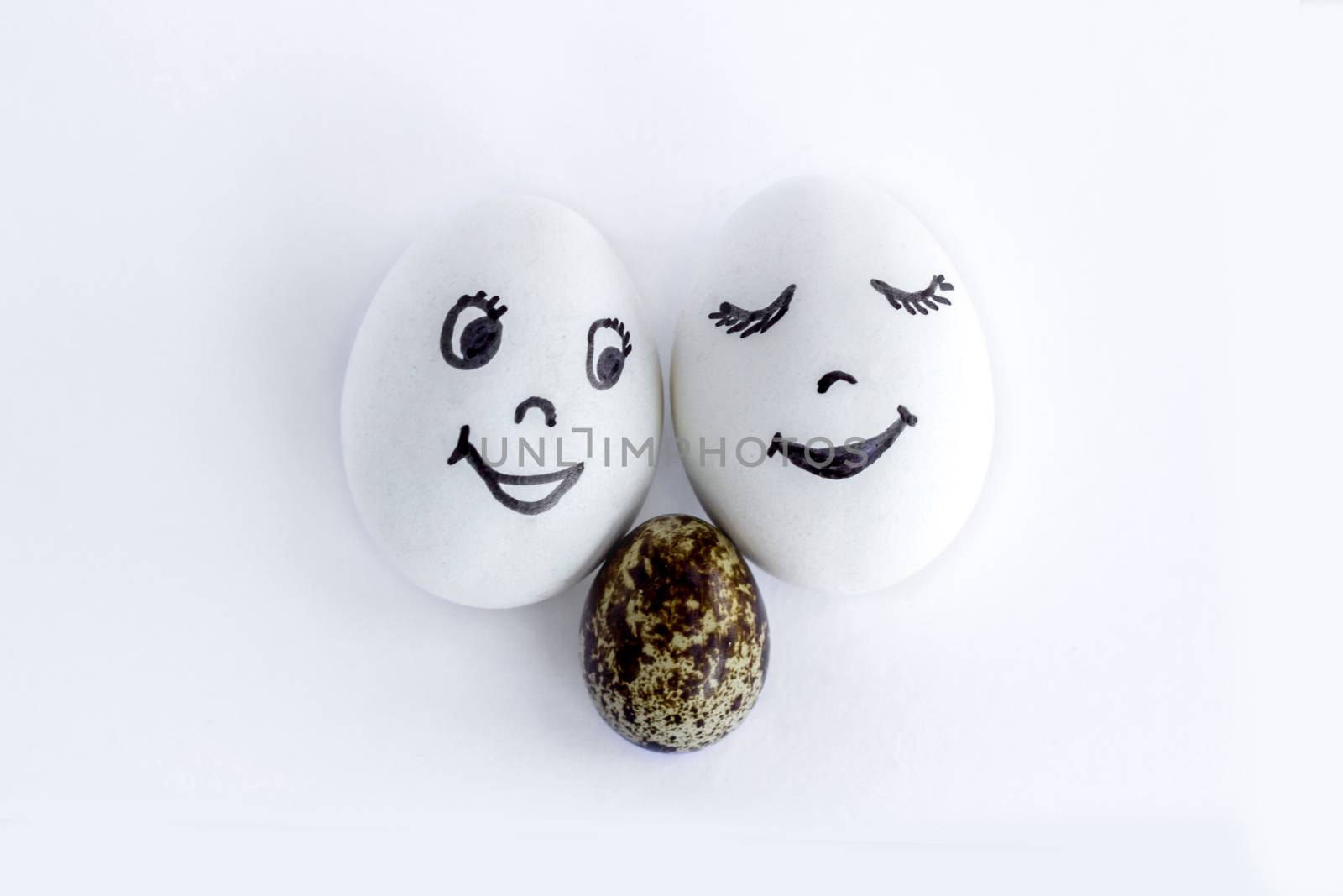 Funny eggs imitating a happy smiling family with baby on white background