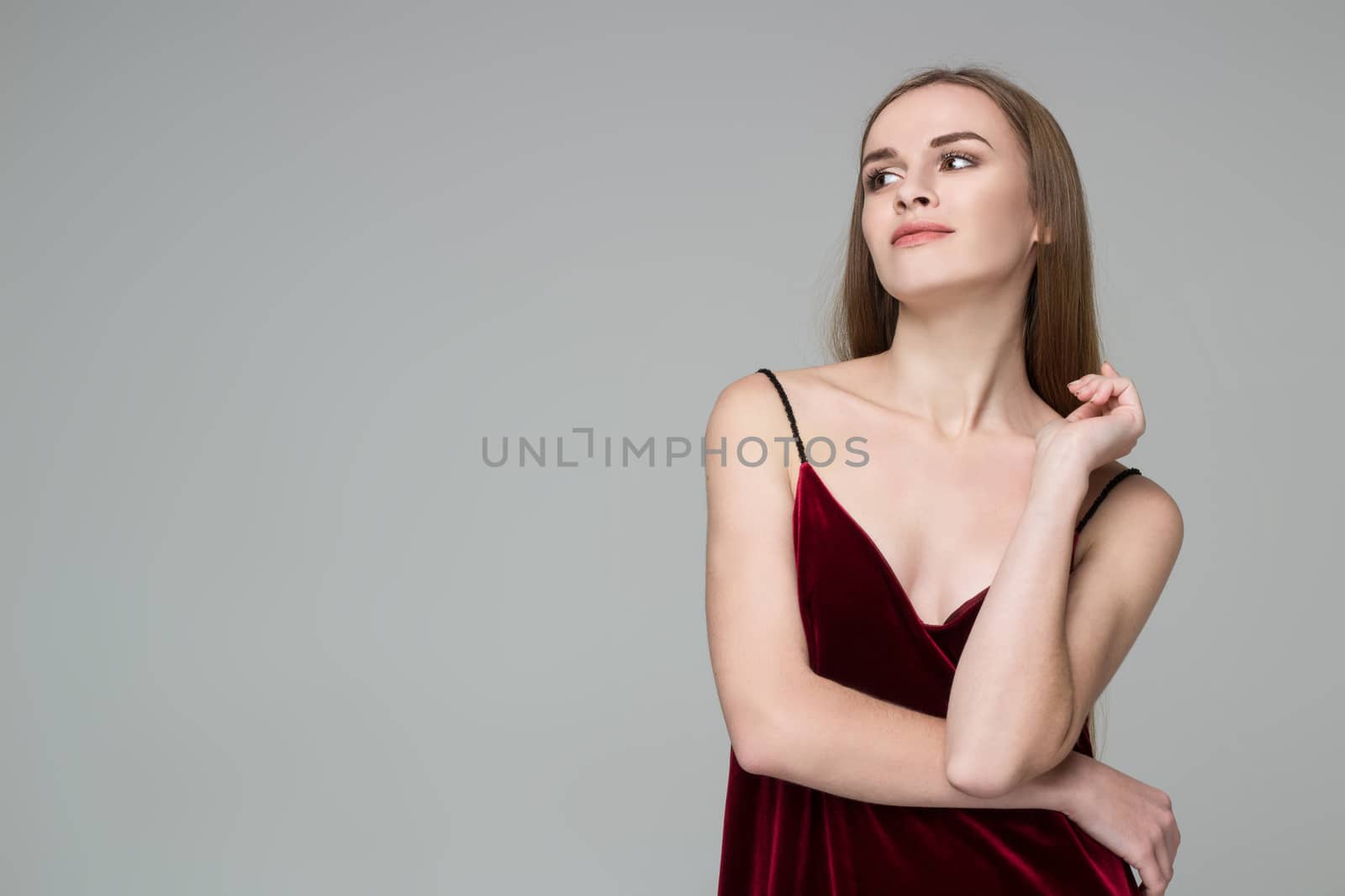 Young blond girl in dark red dress showing emotions: satisfactio by VeraVerano