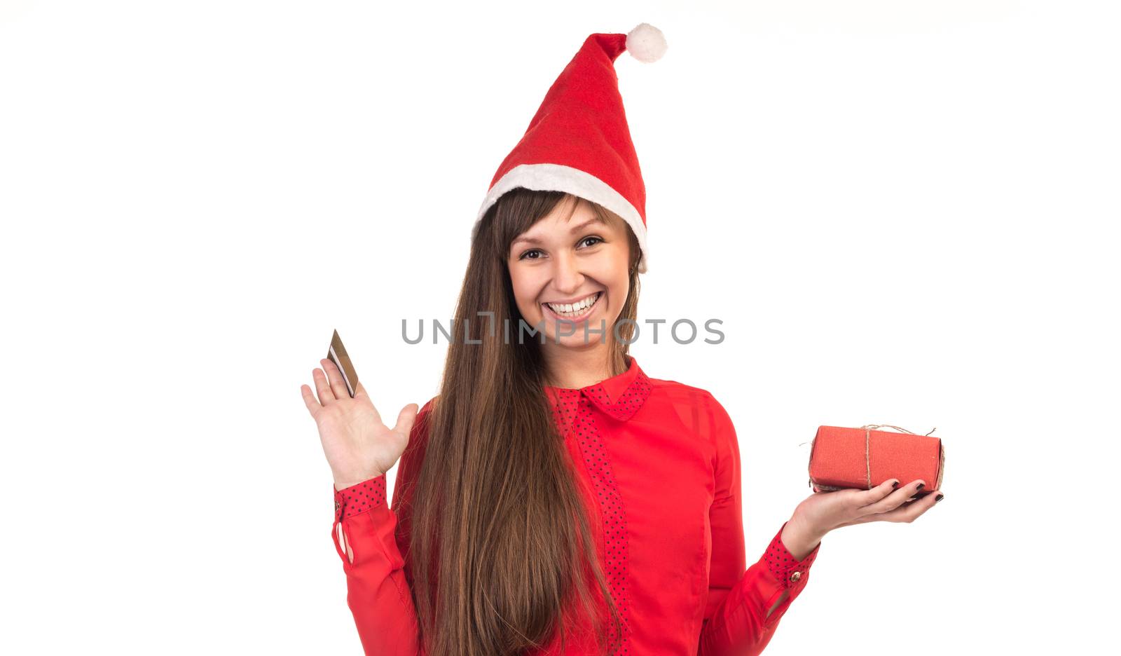 Young long-haired woman in red christmas cap with gold credit card and red gift box