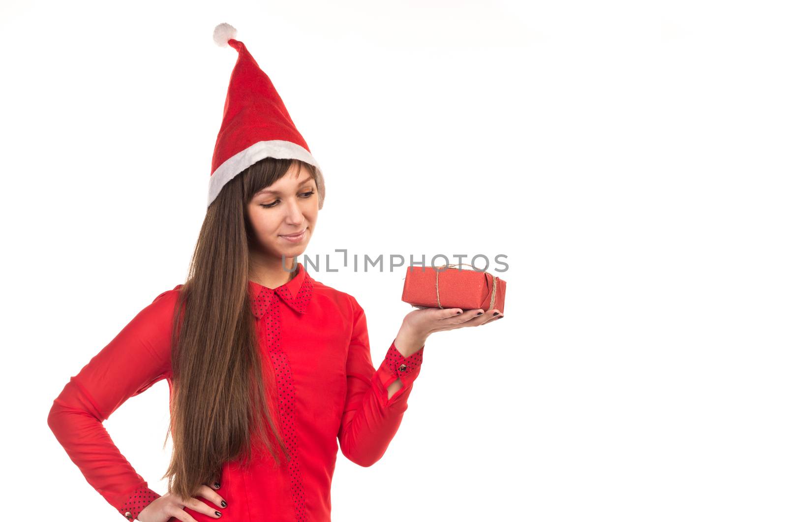 Young long-haired woman in red christmas cap holds red gift box