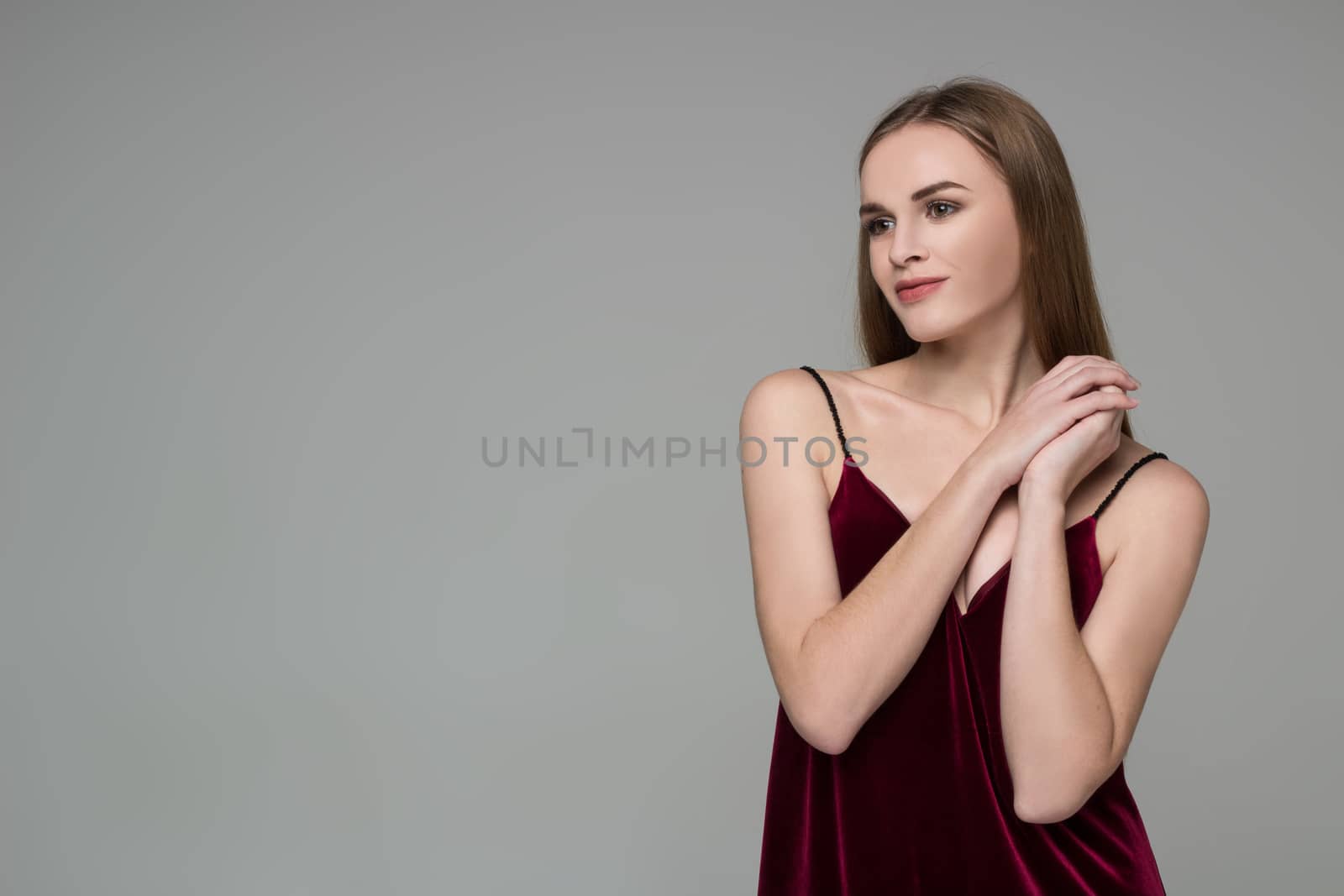 Young blond girl in dark red dress showing emotions: pleasure by VeraVerano