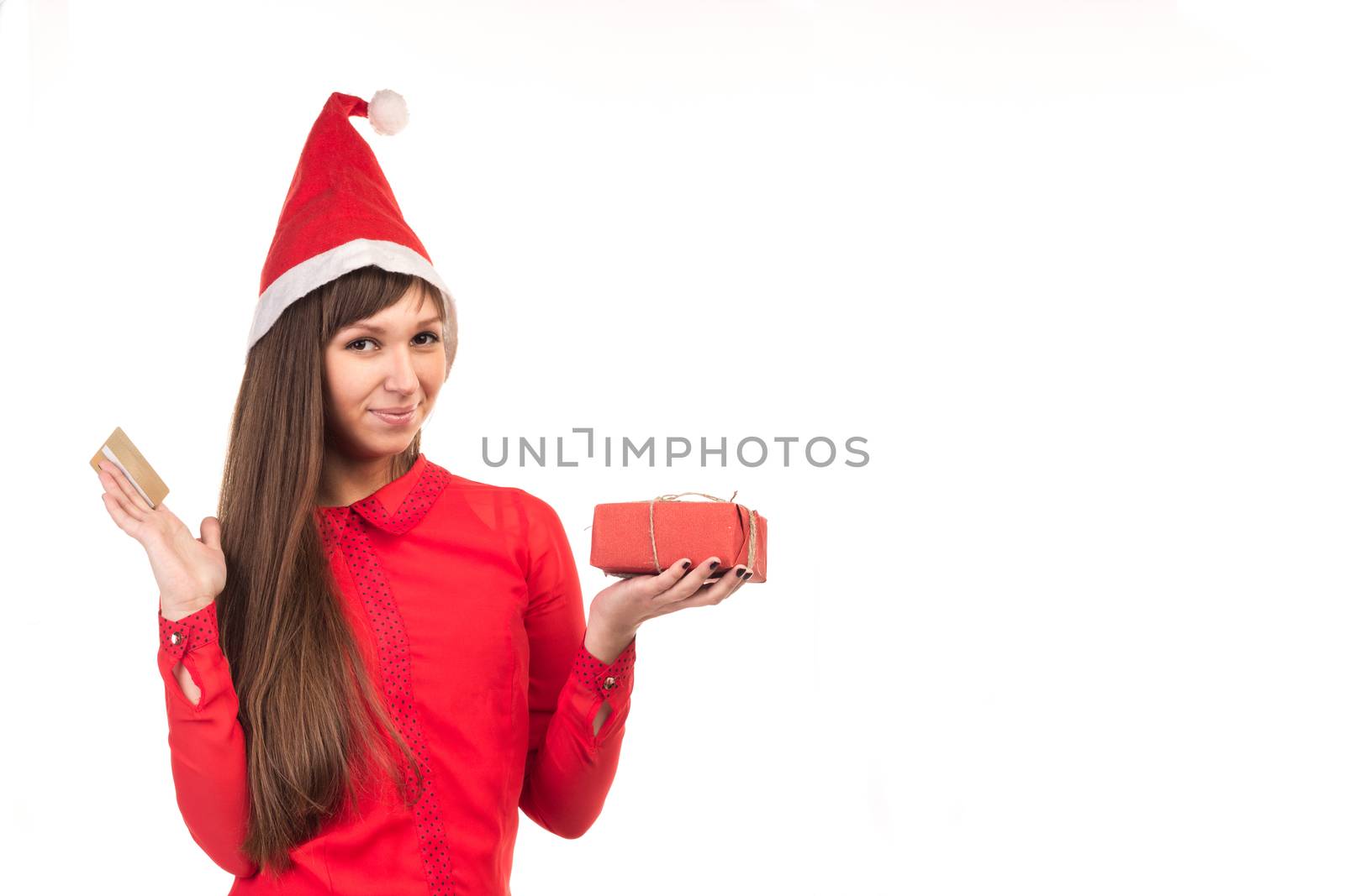 Young long-haired woman in red christmas cap with gold credit card and red gift box