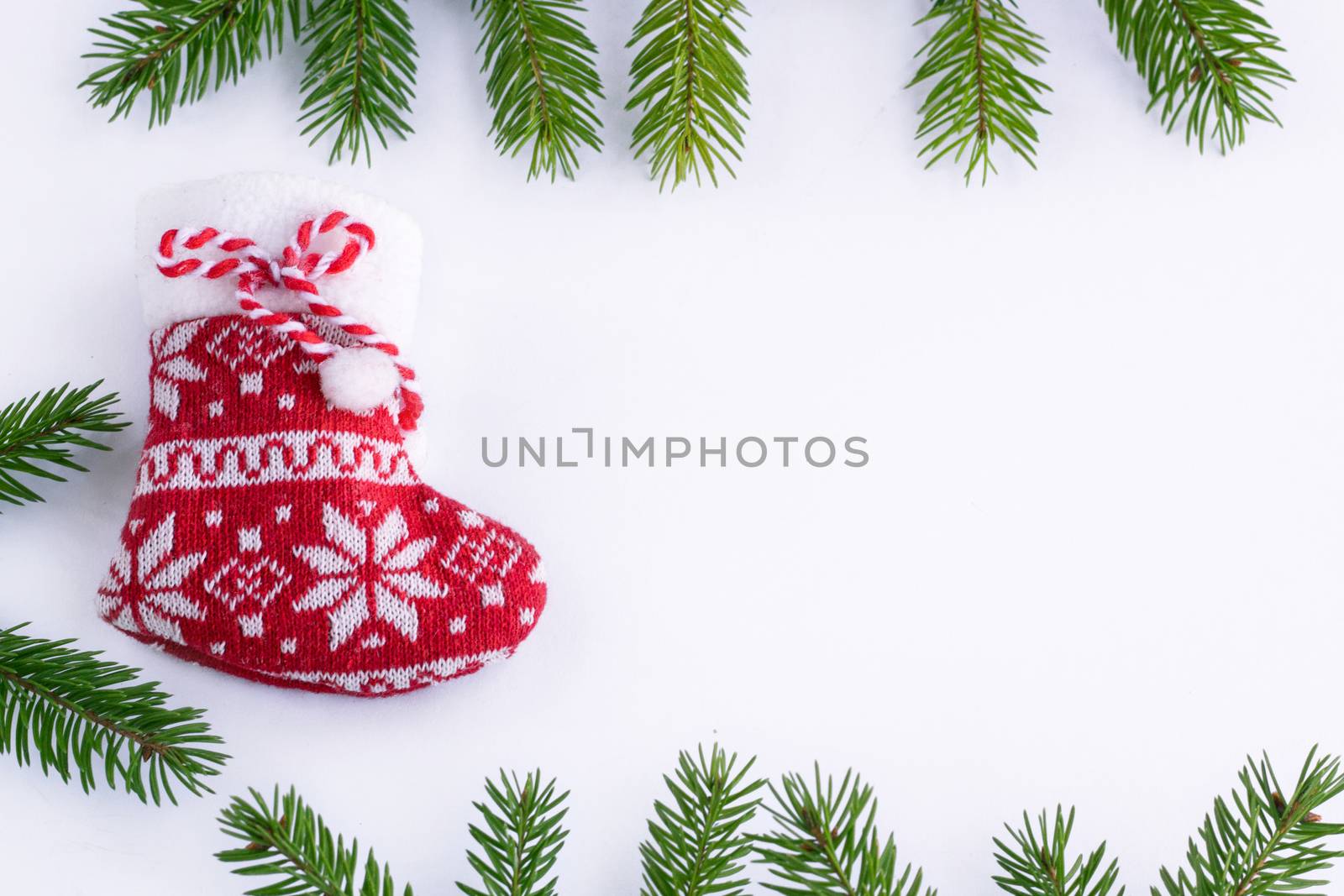 Red Christmas sock on white background, frame of green contiferous fir tree braches