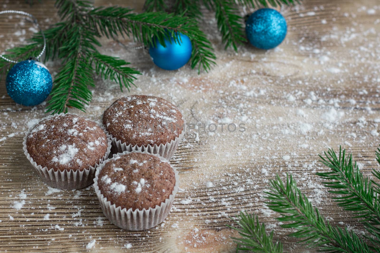 Christmas and New Year winter holiday composition of three cakes on snowbound wooden space background with green fir tree branches  and blue ball ornament