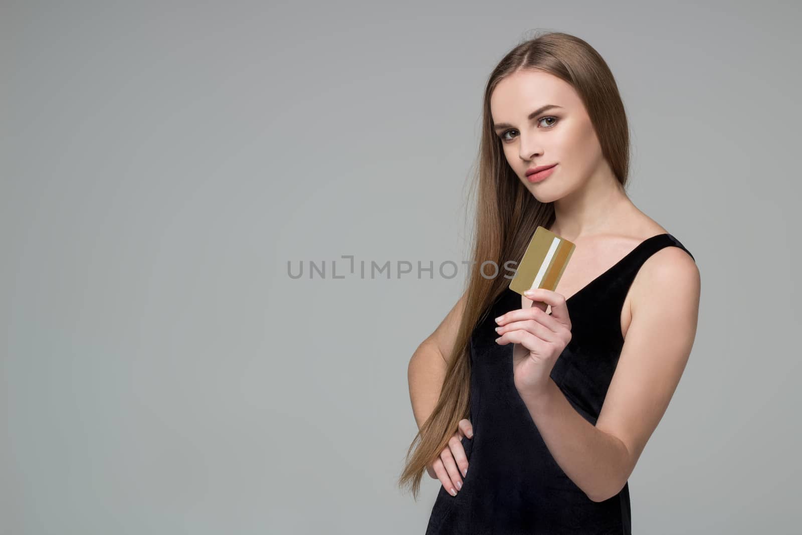 Blond girl in black holds golden credit card shopping payment by VeraVerano