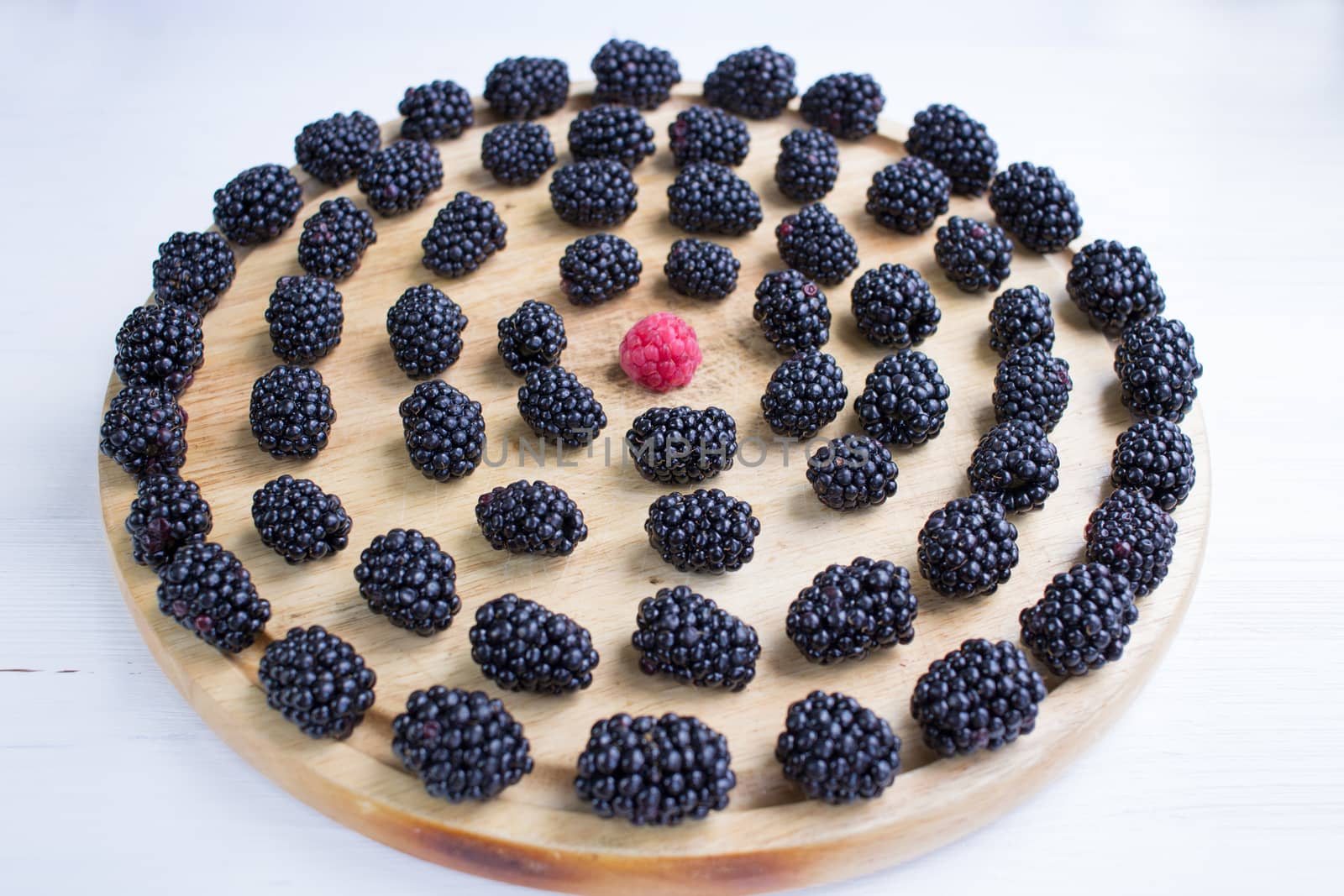 Round set of many blackberries and raspberry on wooden tray by VeraVerano