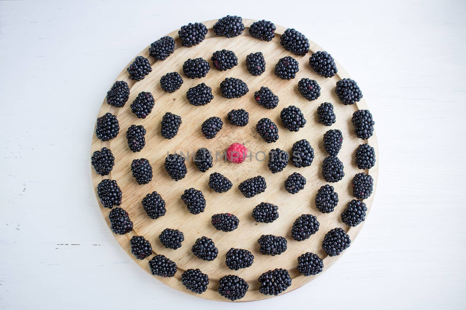 Set of many blackberries and raspberry on round wooden tray by VeraVerano