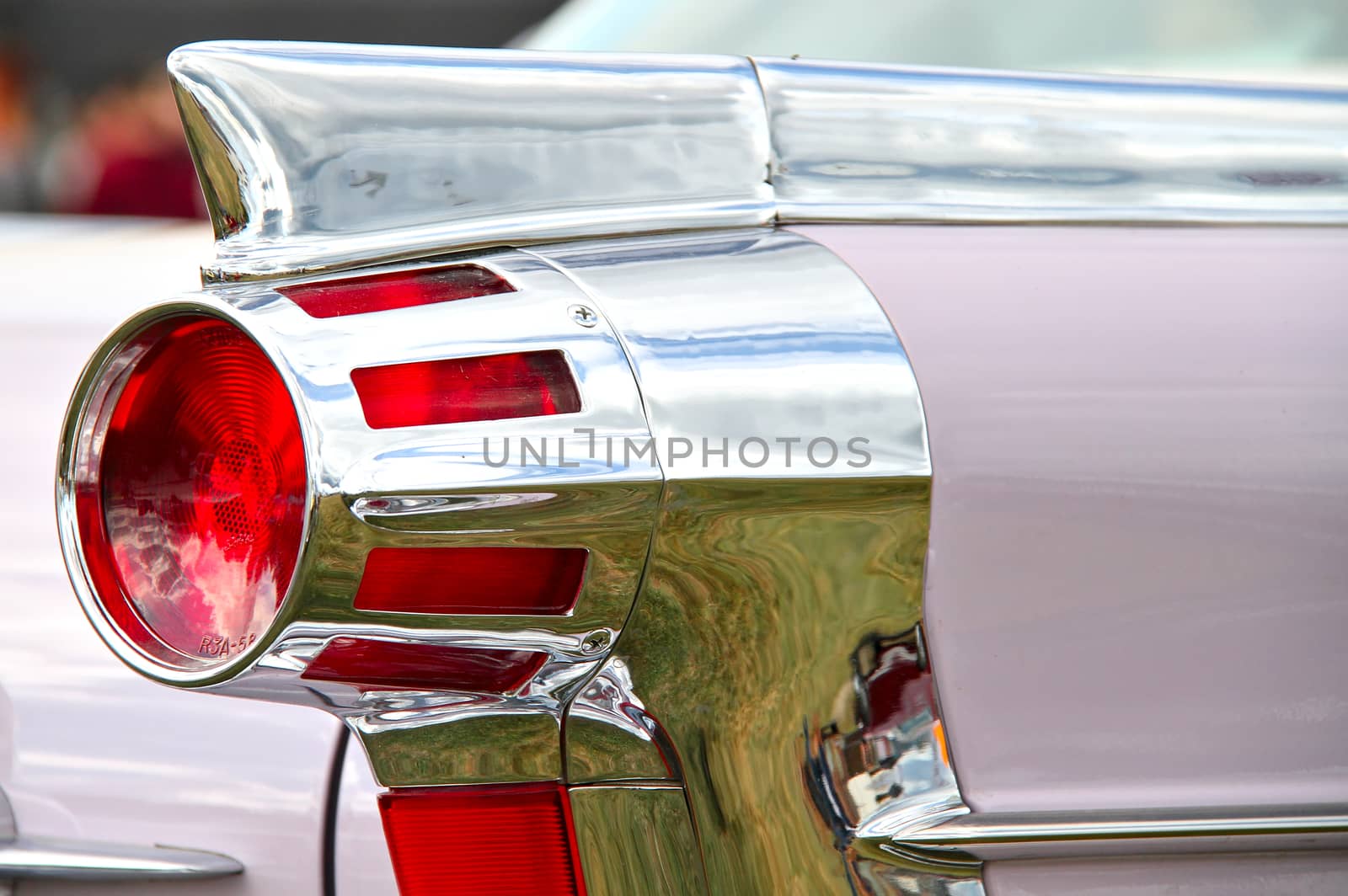 Round taillight of an old american car decorated with chrome.