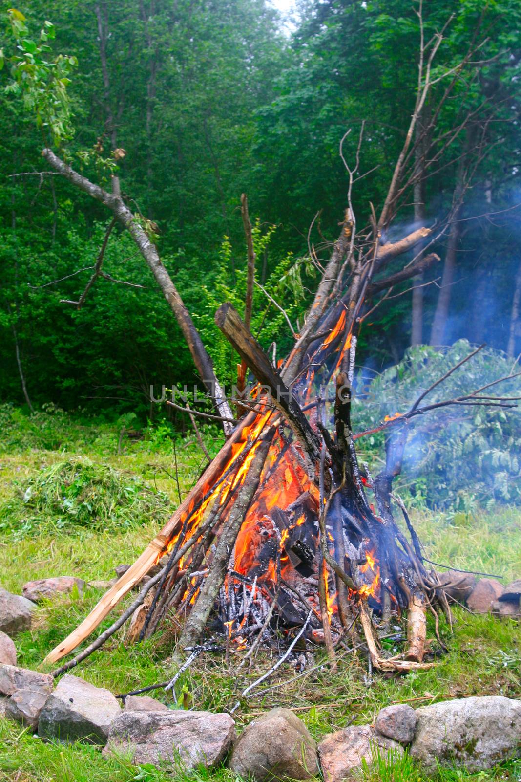 Burning branches at the fireplace to celebrate longest day of the year. The Midsummer.