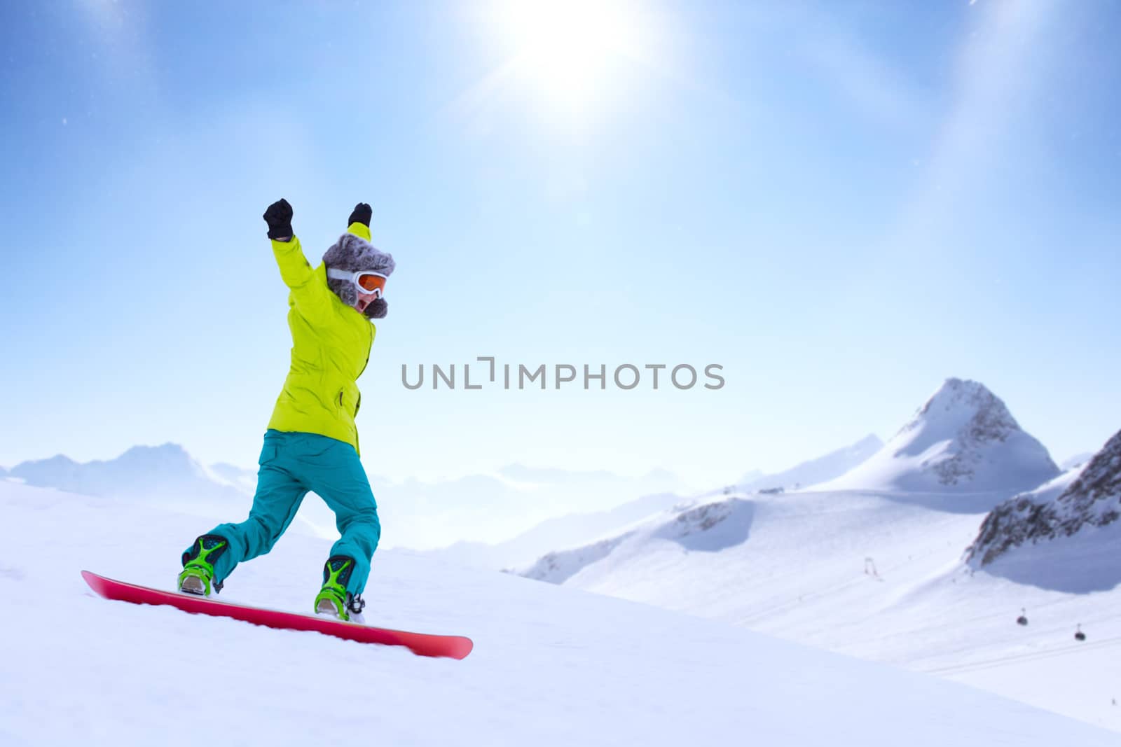 Girl snowboarder running down the slope in Alpine mountains. Winter sport and recreation, leisure outdoor activities. Image of excited screaming young woman enjoyment concept