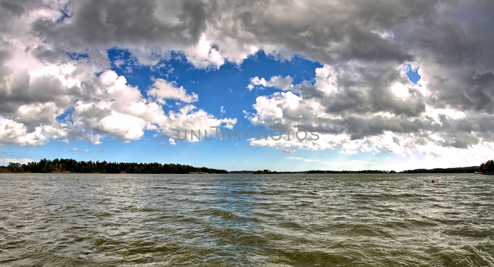 Photo of beautiful cloudy sky and dark grey water surface.