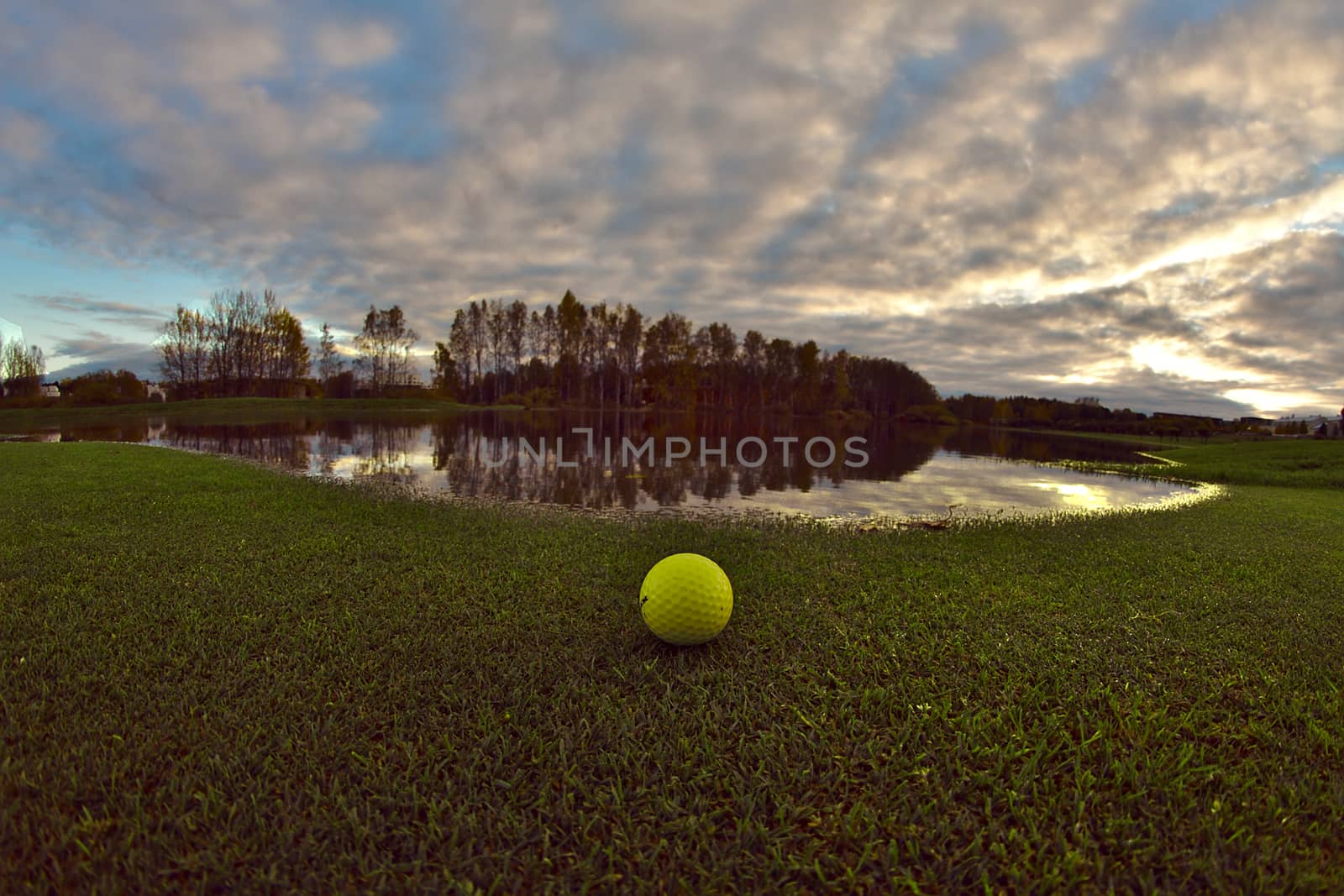 An empty golf course with one lonely golf ball left on the lawn for the night.