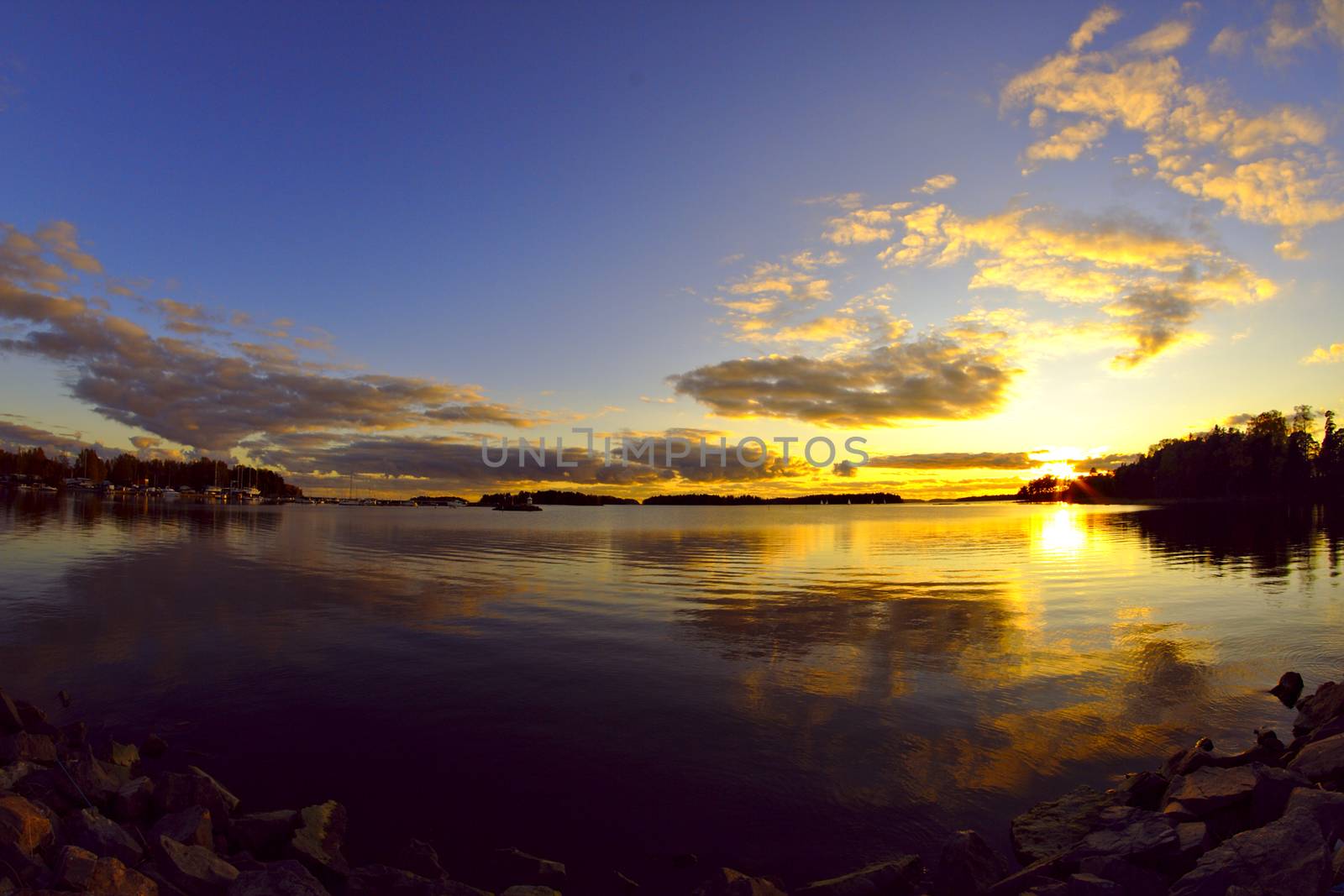 Stunning mid summer sunset by the water. Sunset reflecting from the surface.