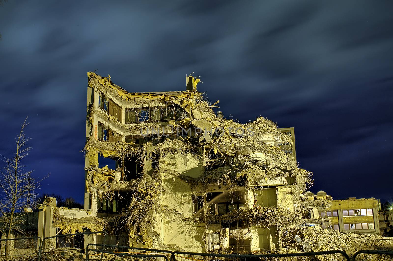 Apocalyptic photo of a heavily damaged concrete office building. Only two walls with broken windows still standing.