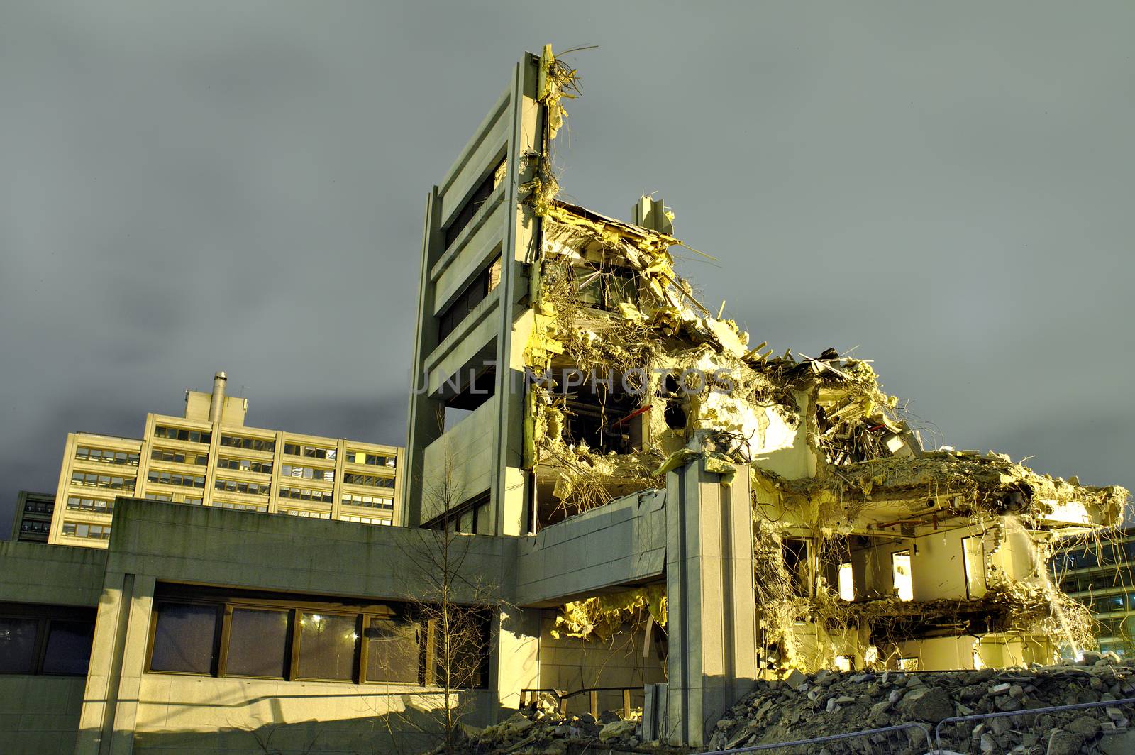 Only small part of a destroyed building still standing. Roof and most of the walls have collapsed. Dramatic night scene of a demolished concrete building.