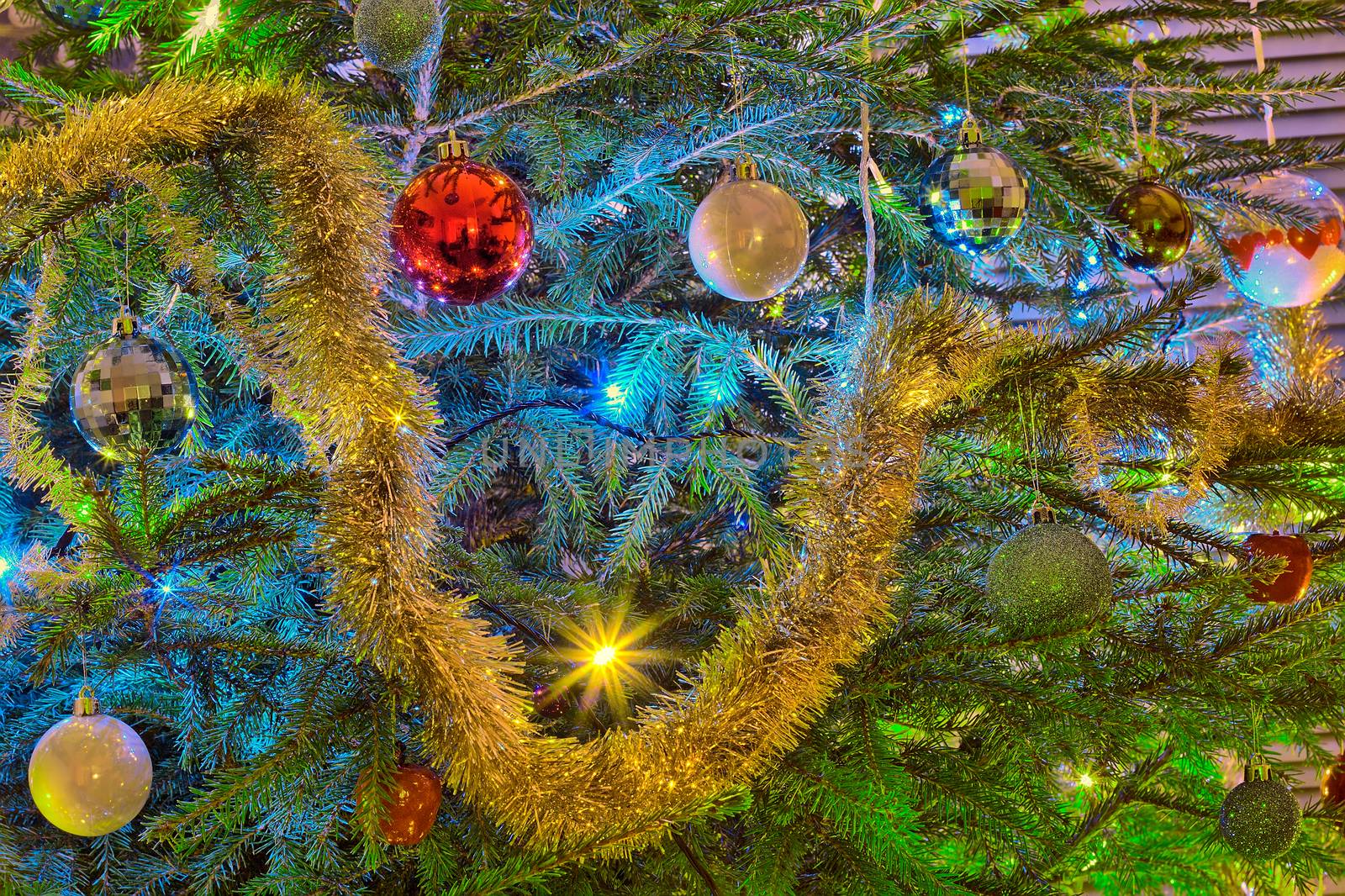 Christmas decorations on Christmas tree looking like a happy smiley face. Golden sparkling decorations and round ornaments.