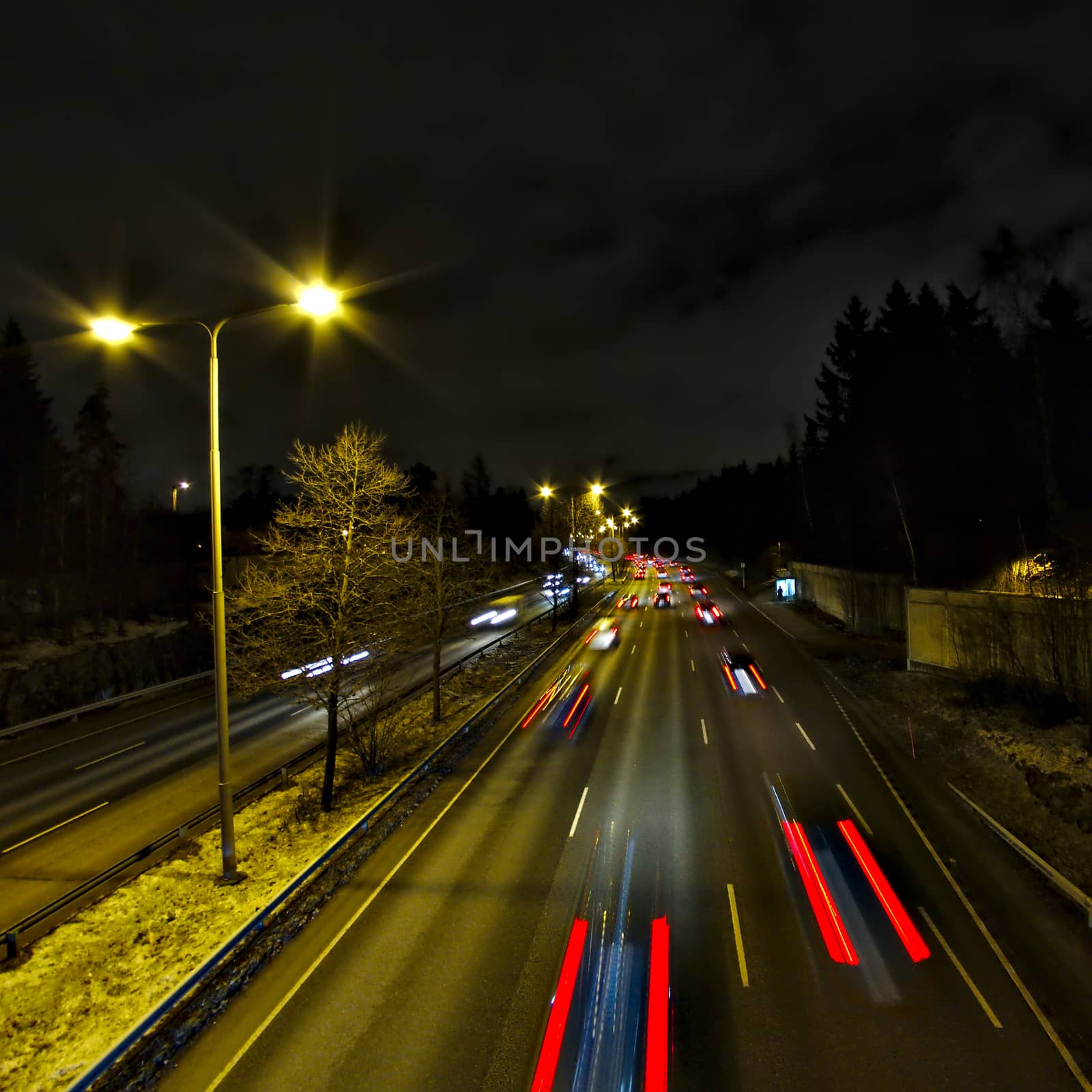 Late night rush hour. People driving home from work in the city. Light trails, long exposure.